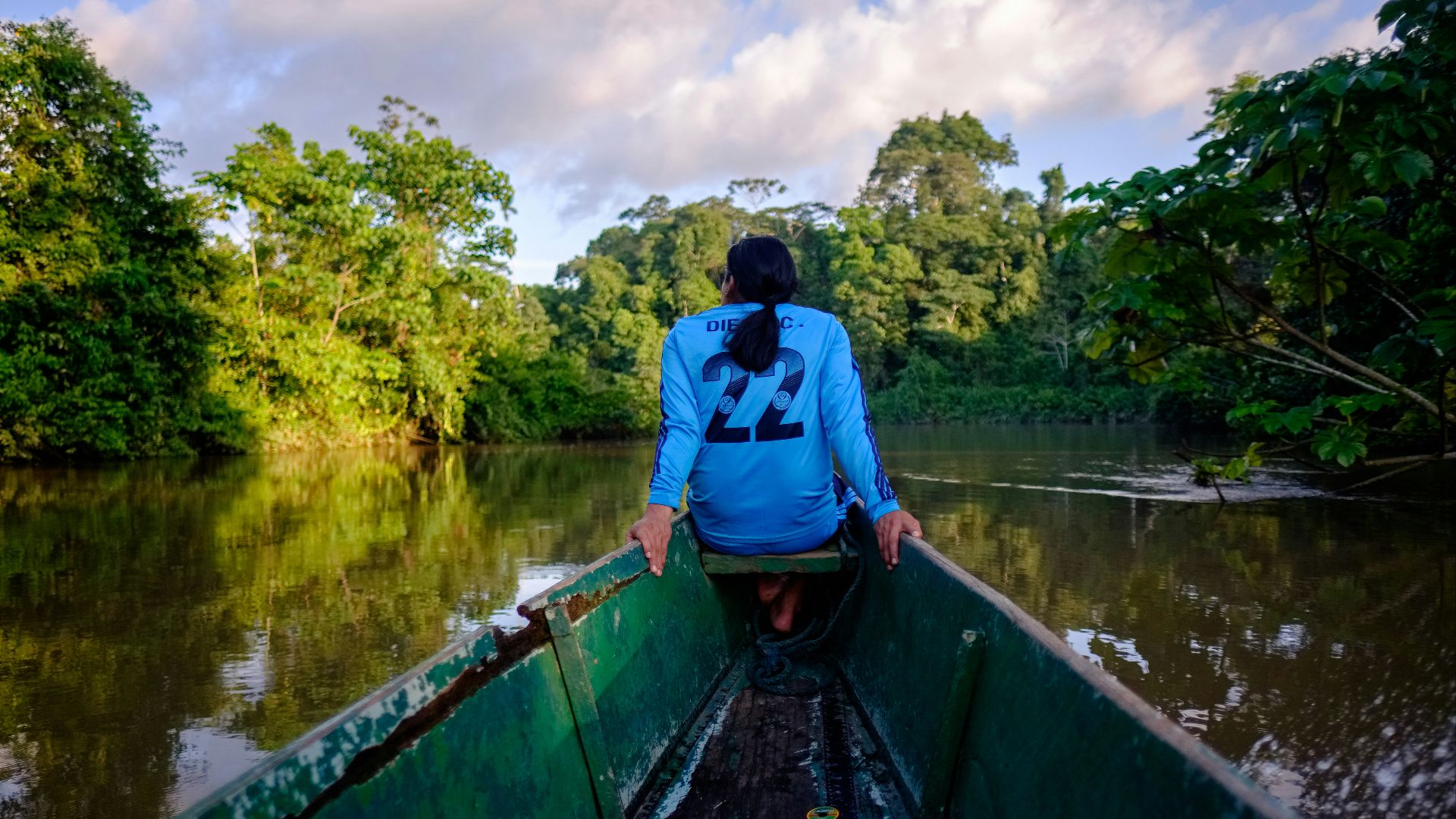a woman sitting in a boat on a river