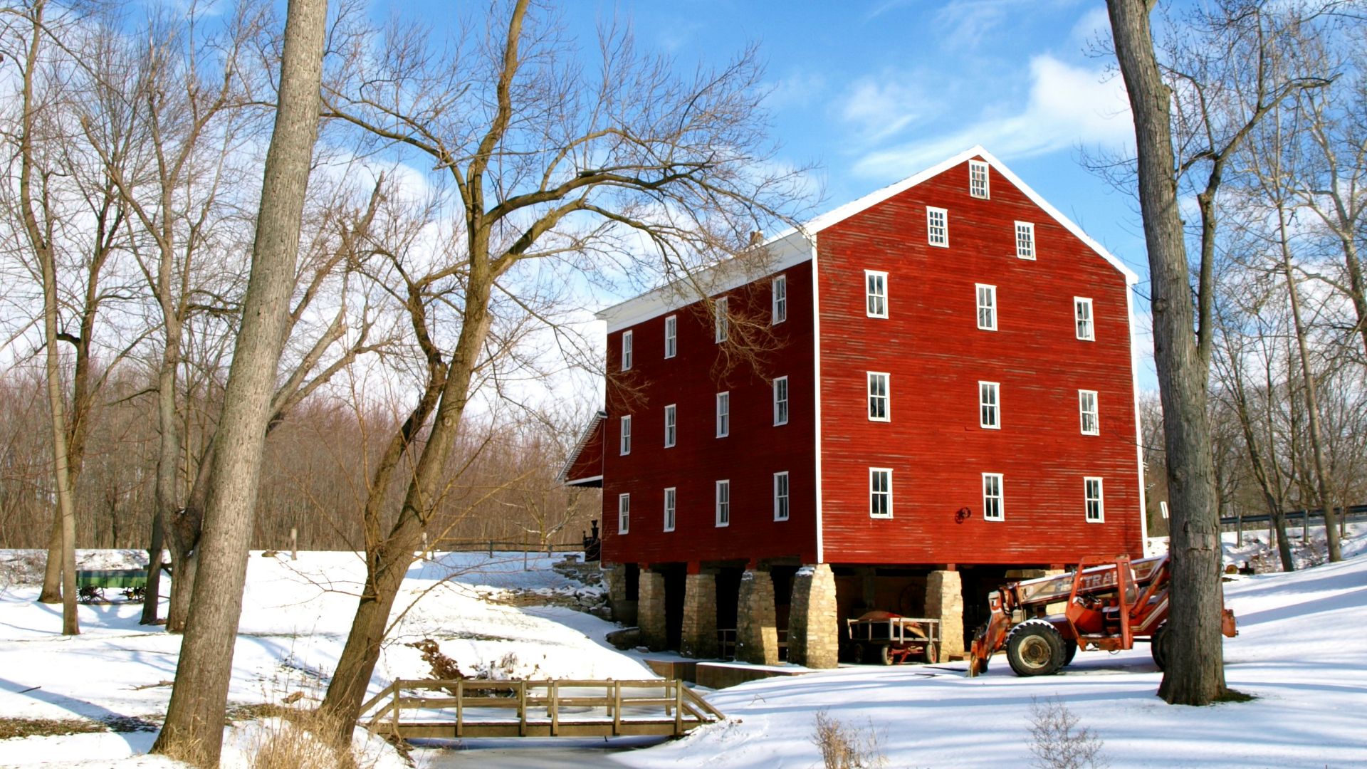 a red barn in the middle of a snowy field