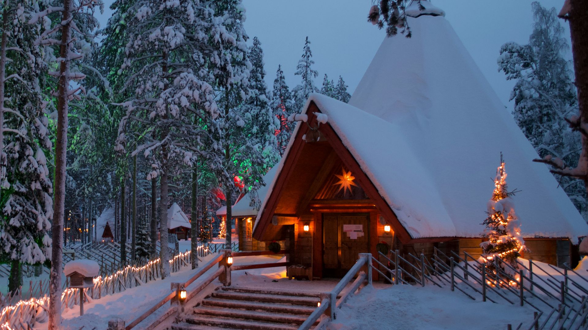 a cabin in the woods is lit up with christmas lights