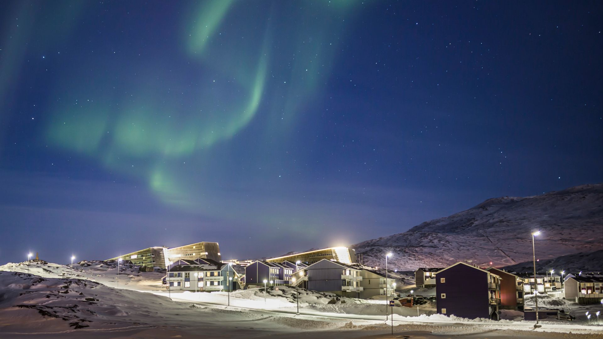 white and brown houses under green sky during night time