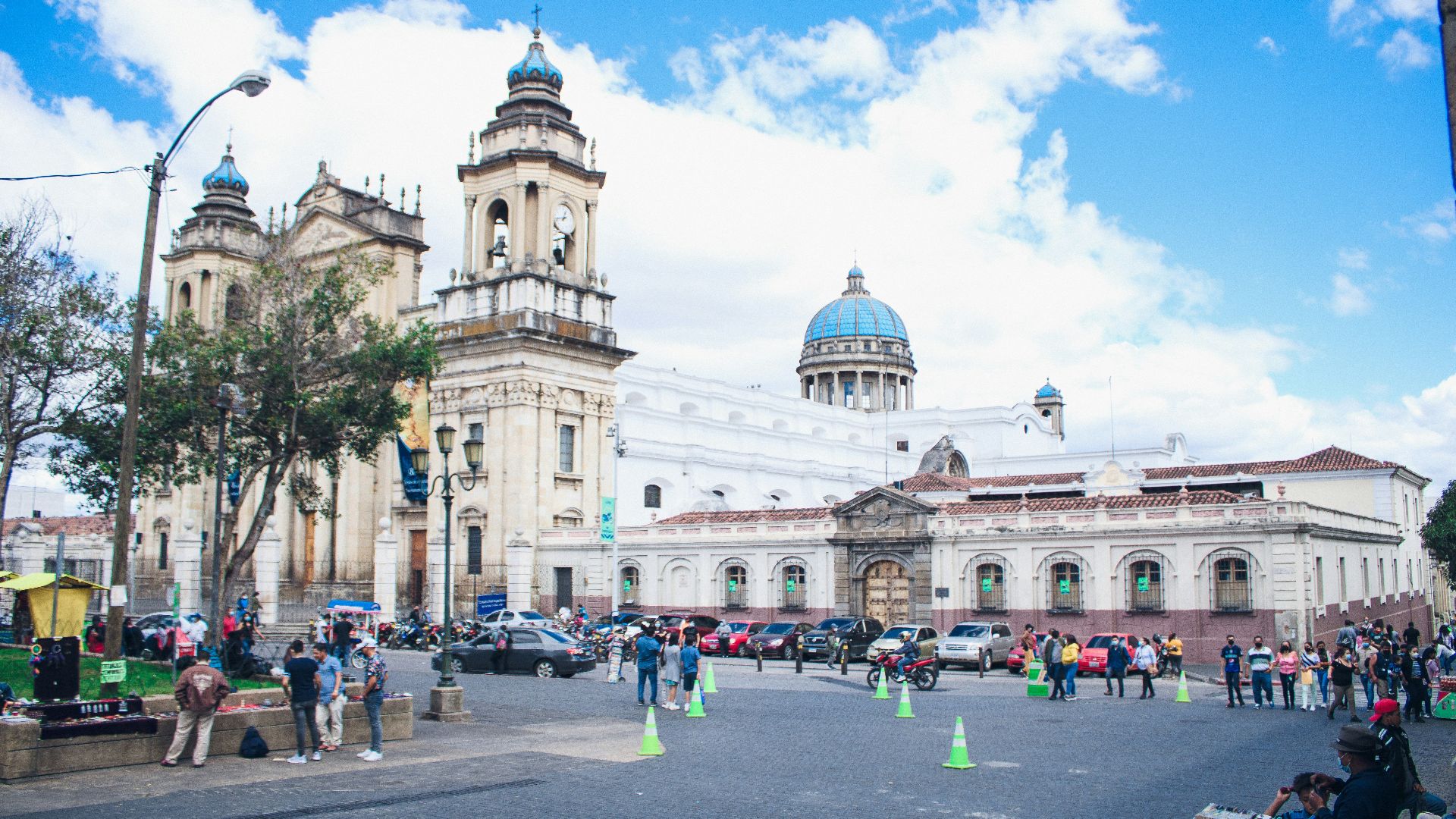 a large white building with a dome and towers and a parking lot