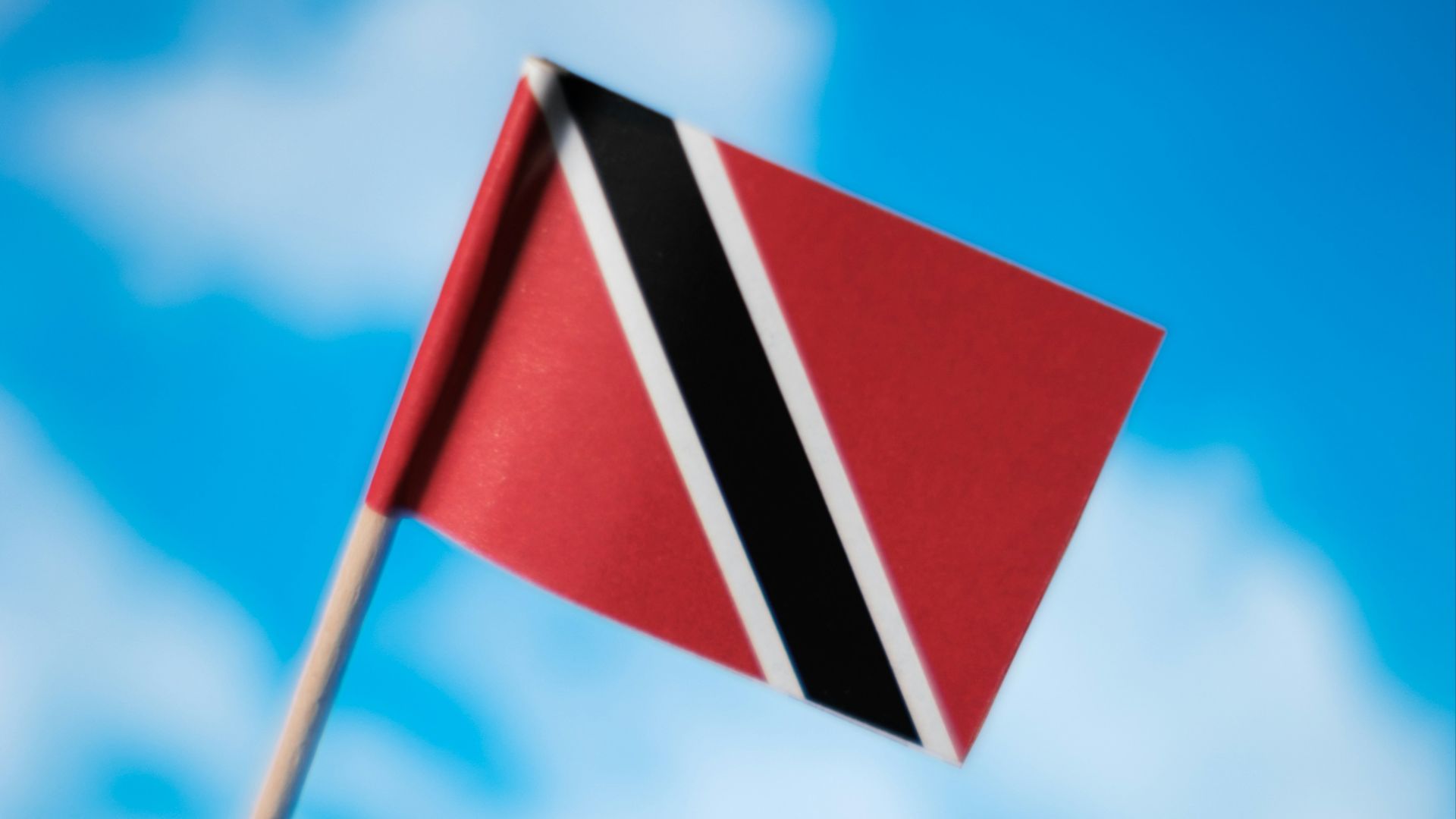 a flag flying in the wind with a blue sky in the background
