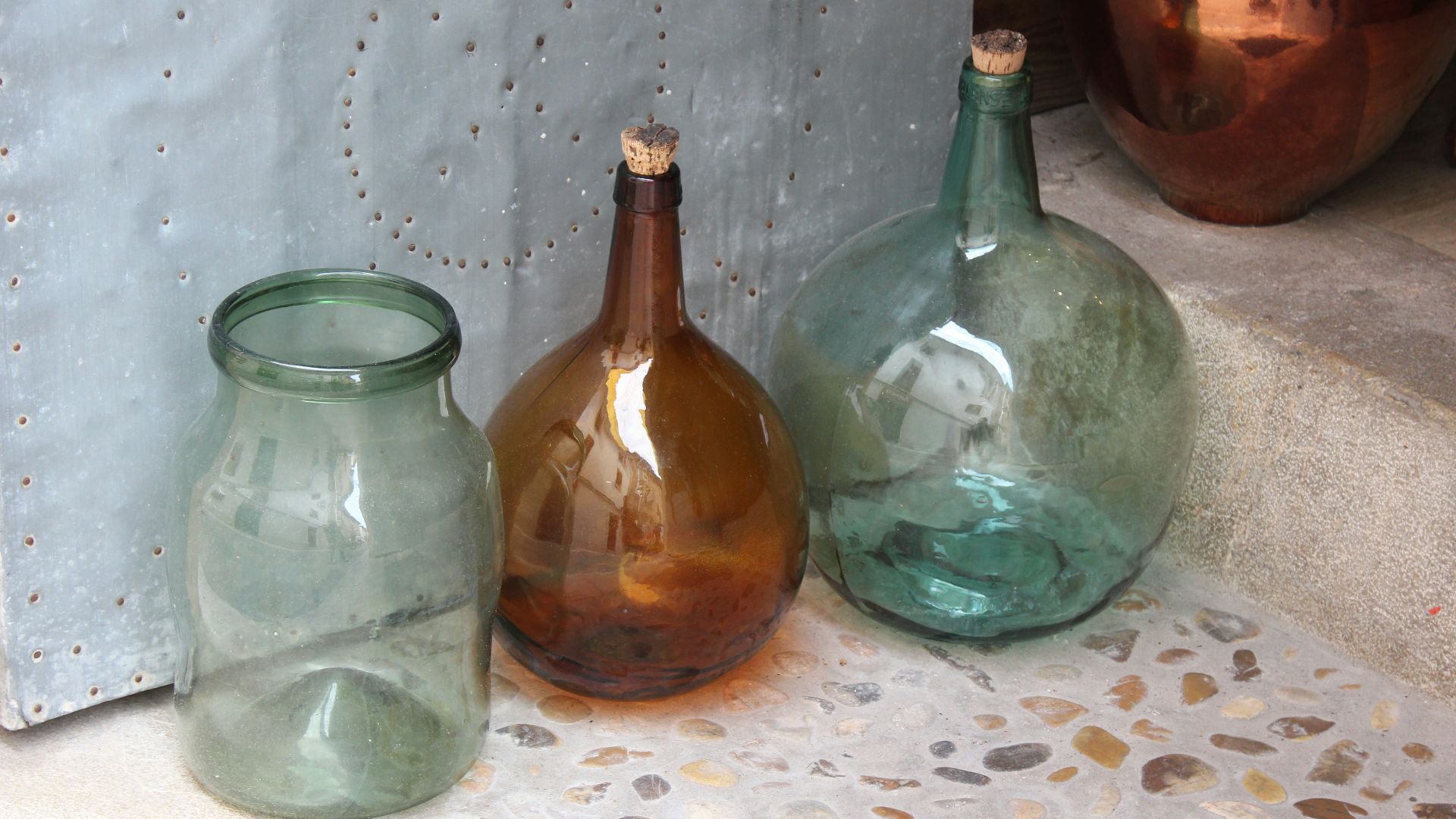 three different colored glass vases sitting on a counter