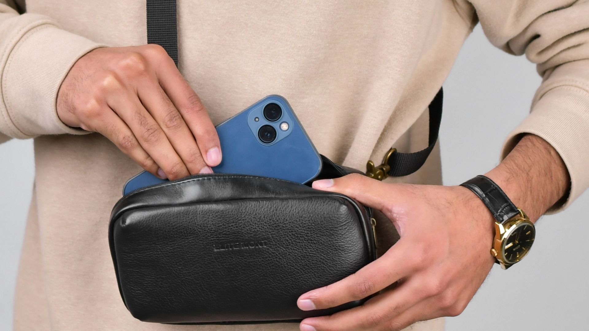 a man holding a black case with a blue phone in it