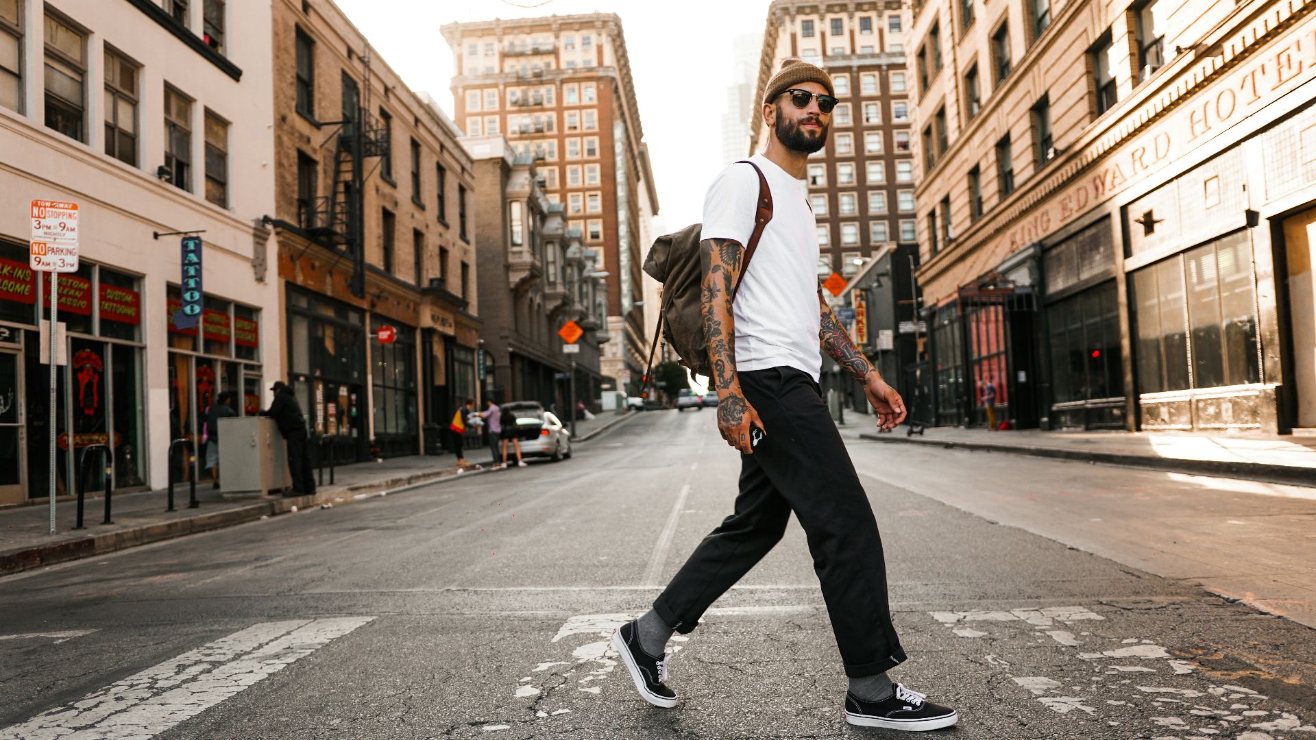 man in white long sleeve shirt and black pants standing on road during daytime