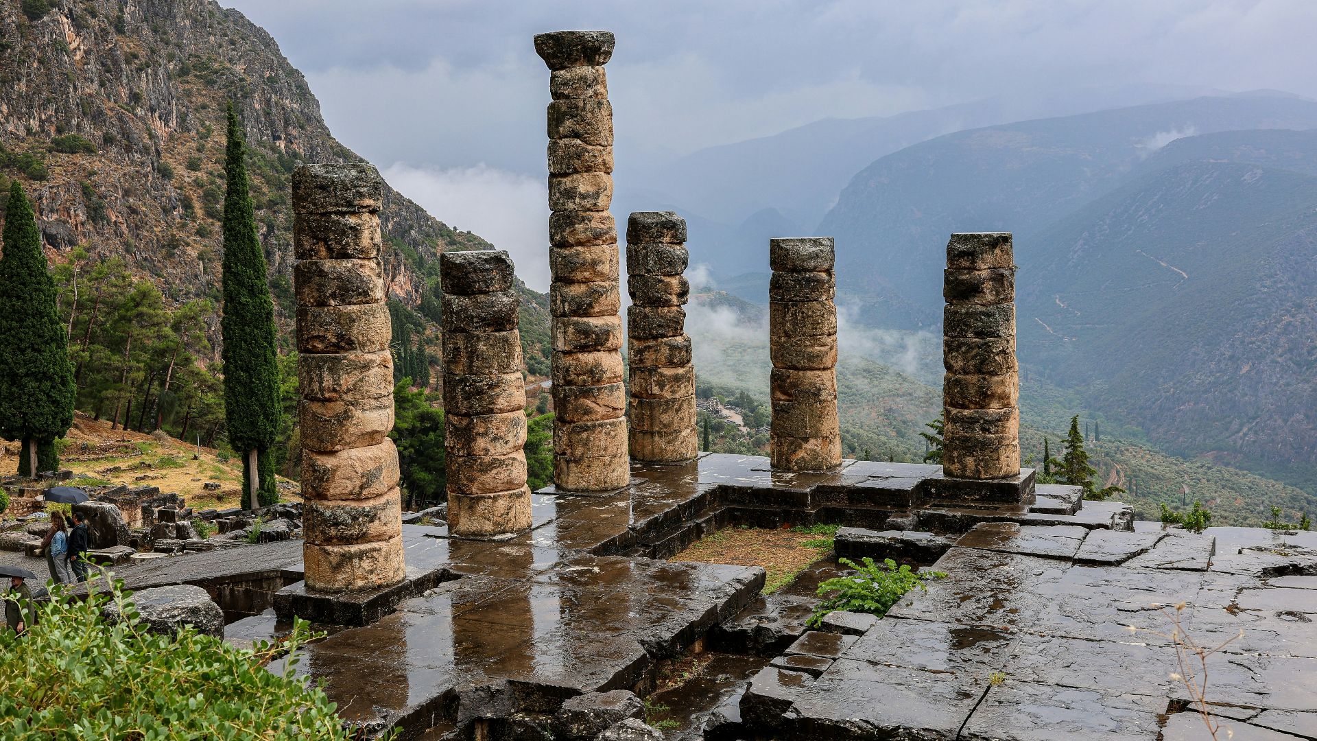 a group of stone pillars sitting on top of a lush green hillside