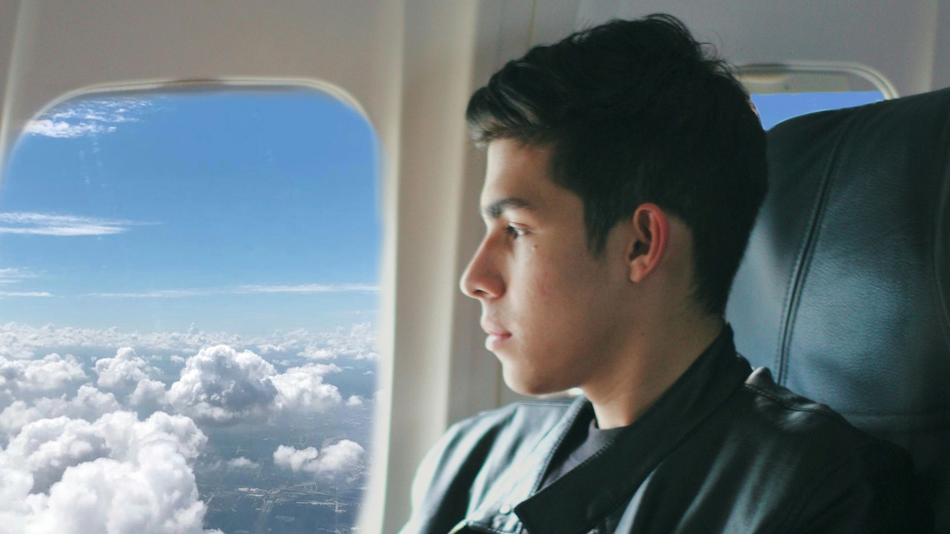 a man sitting in an airplane looking out the window