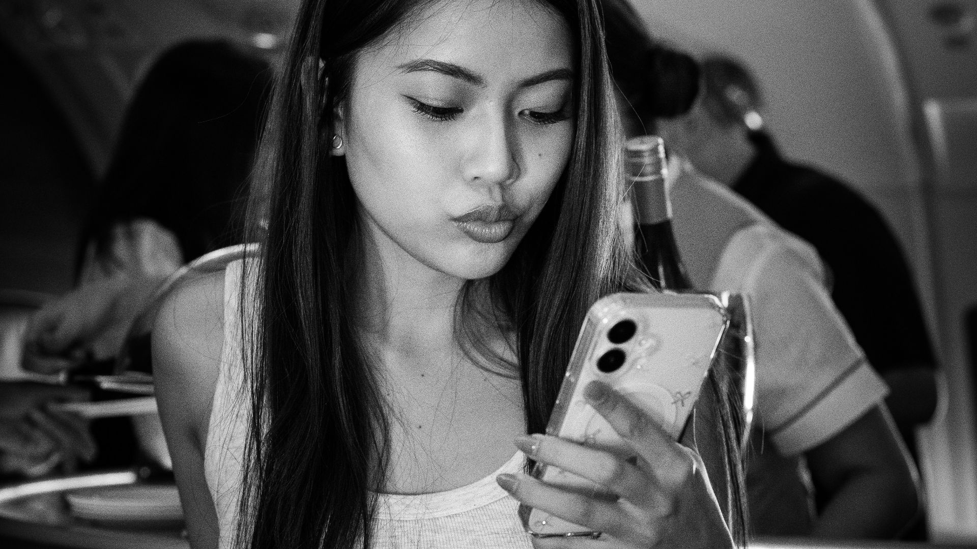 Woman on a plane looking at her phone.