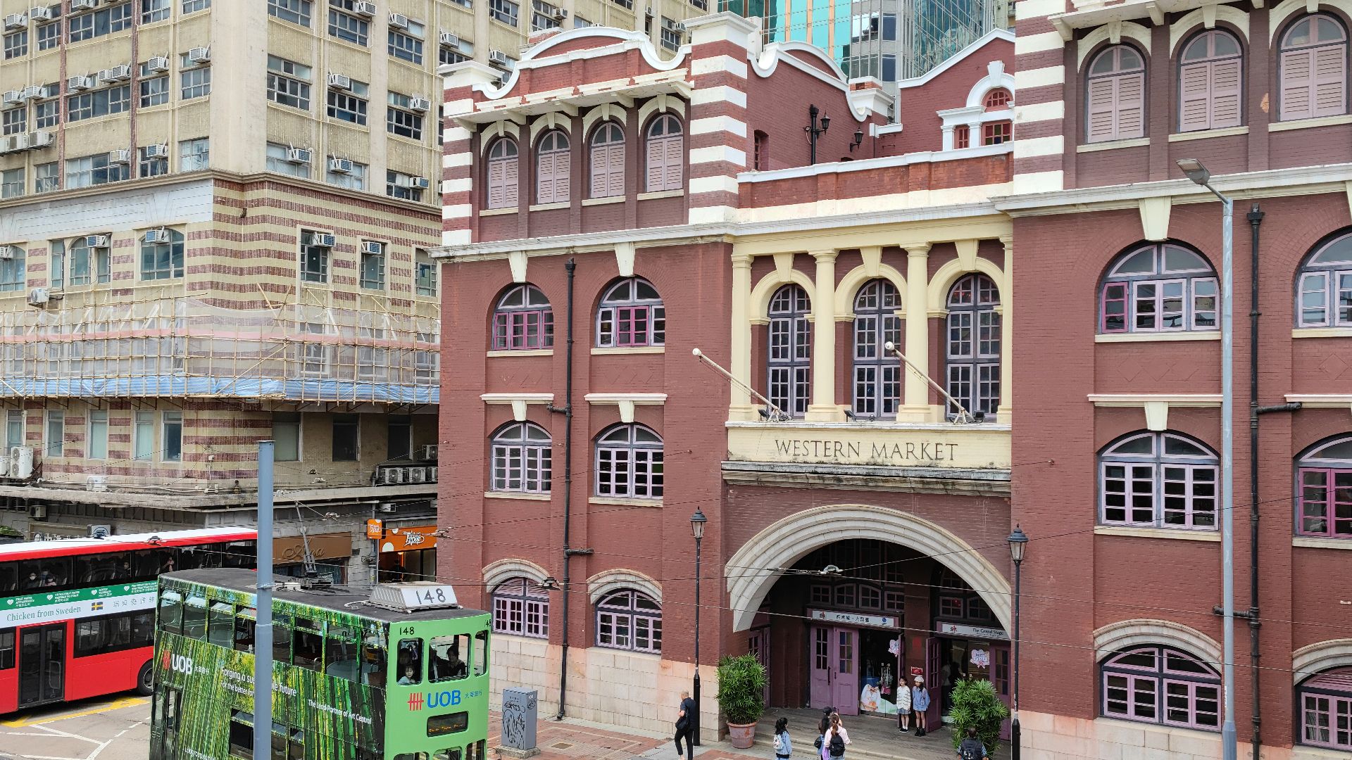 a green double decker bus parked in front of a building