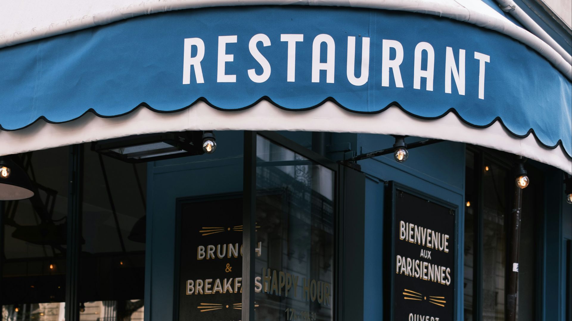 the outside of a restaurant with tables and chairs