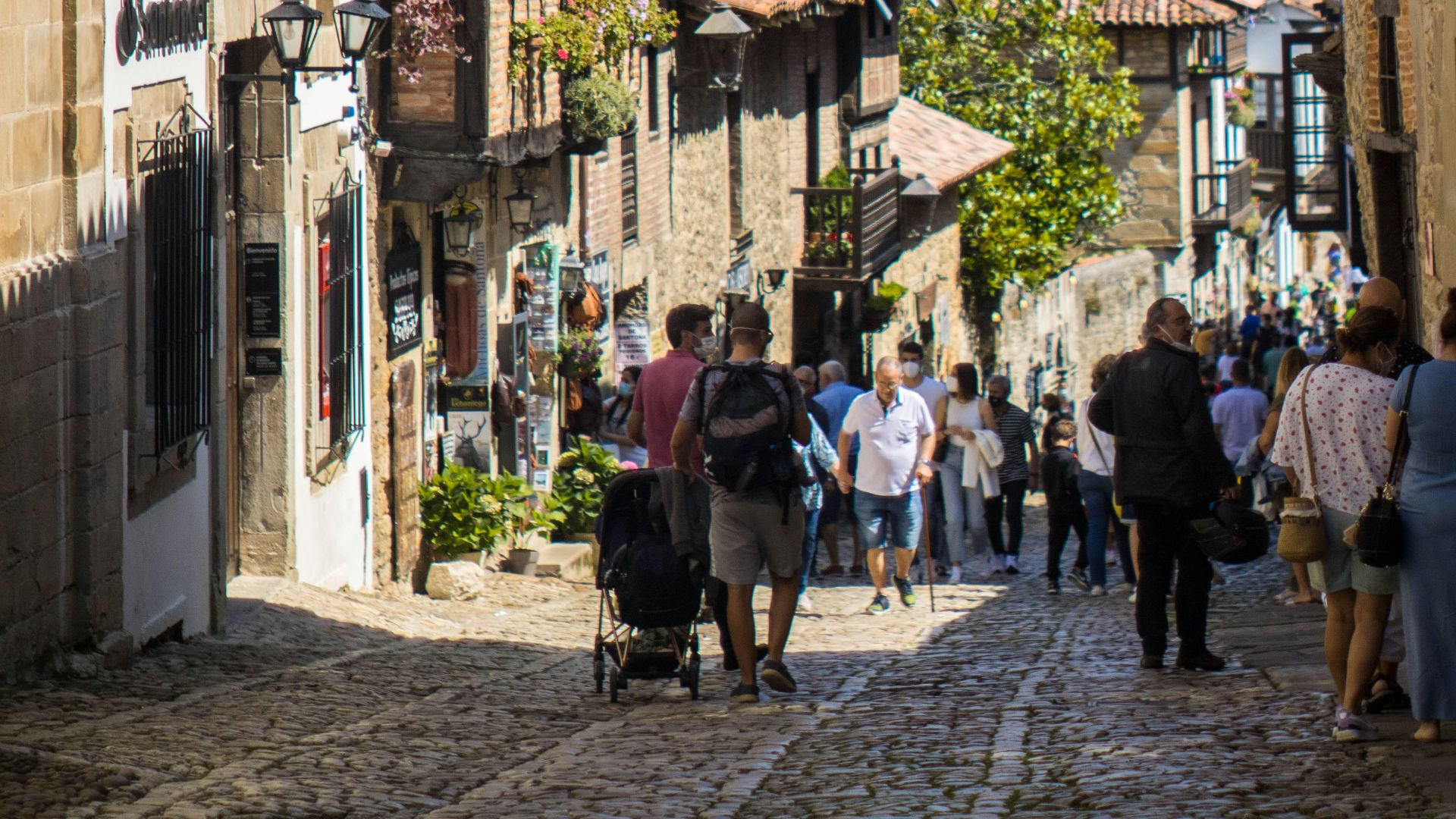 a group of people walking down a cobblestone street