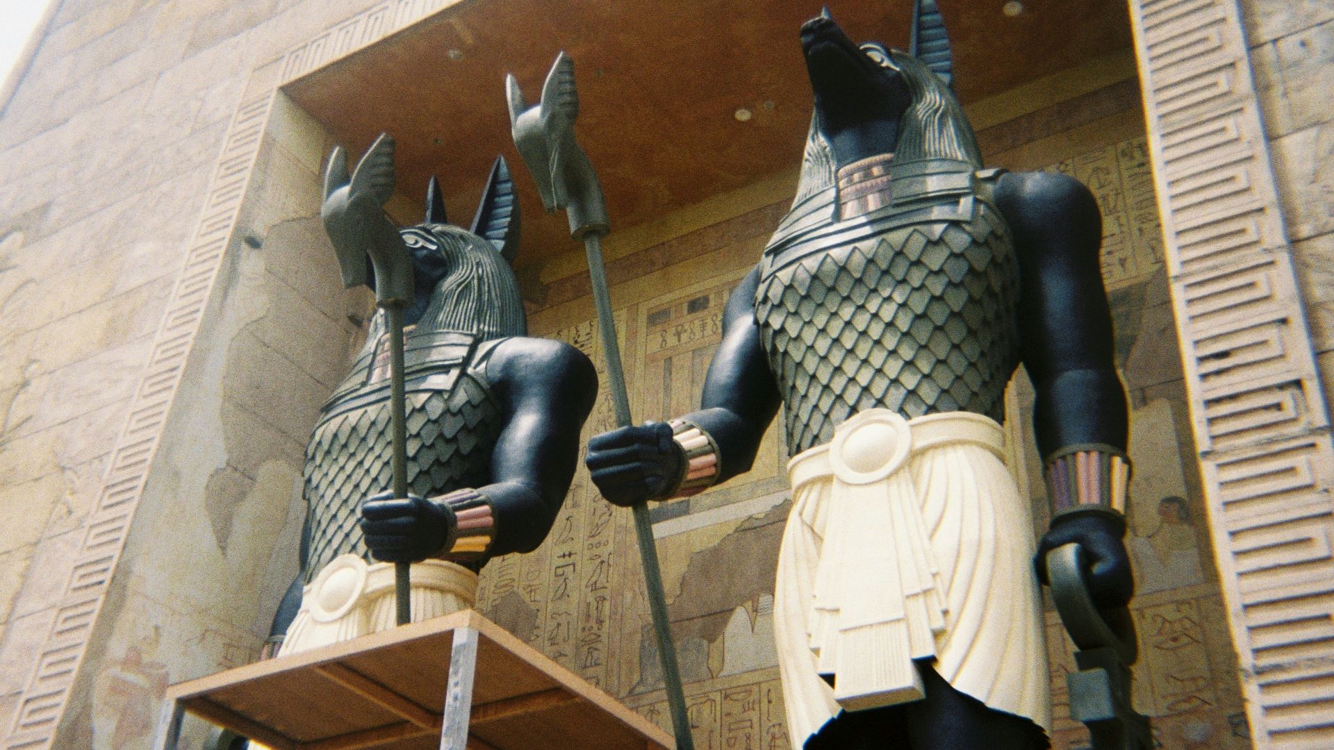 a couple of statues of egyptian gods in front of a building