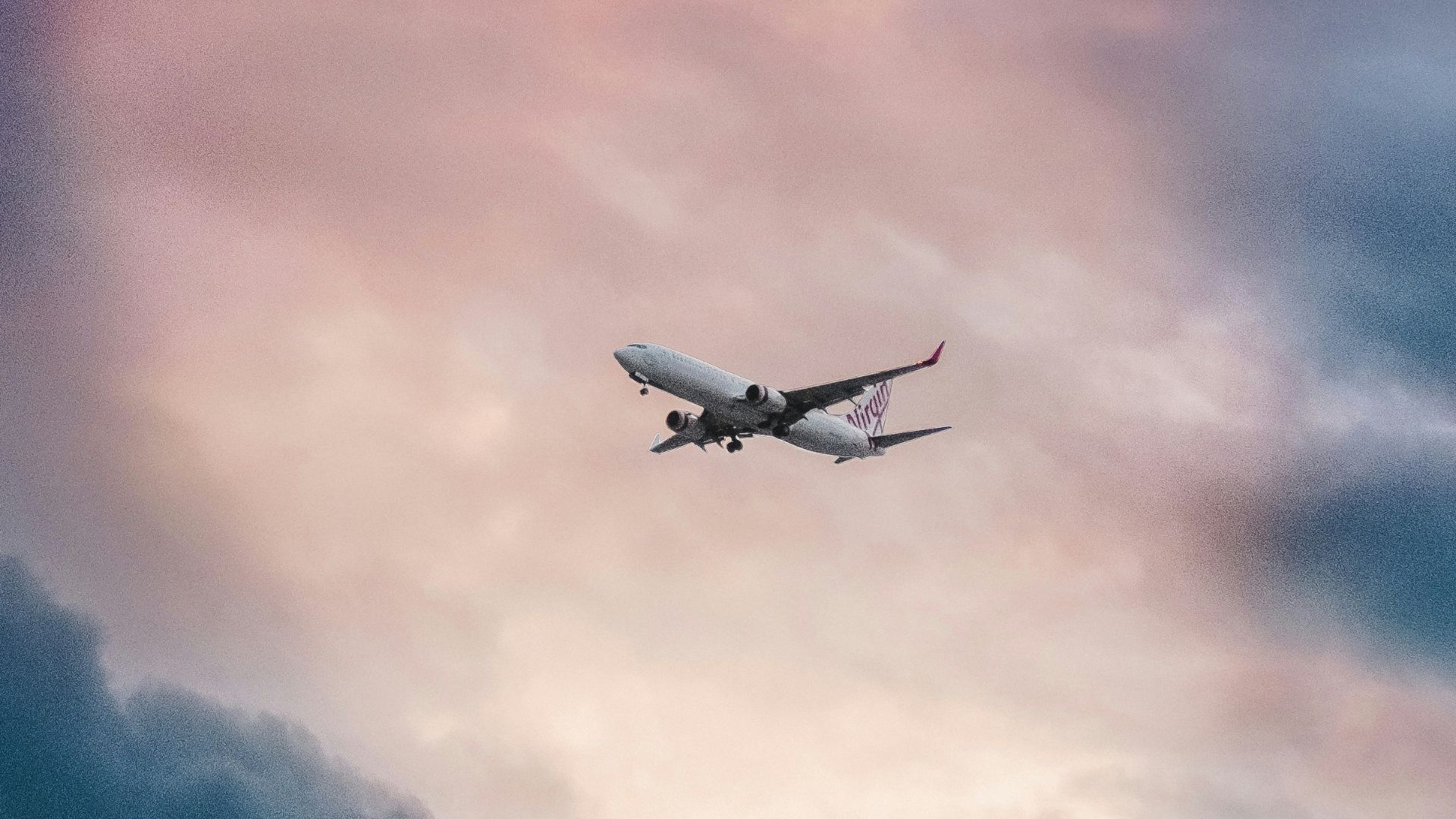 white plane flying over gray clouds