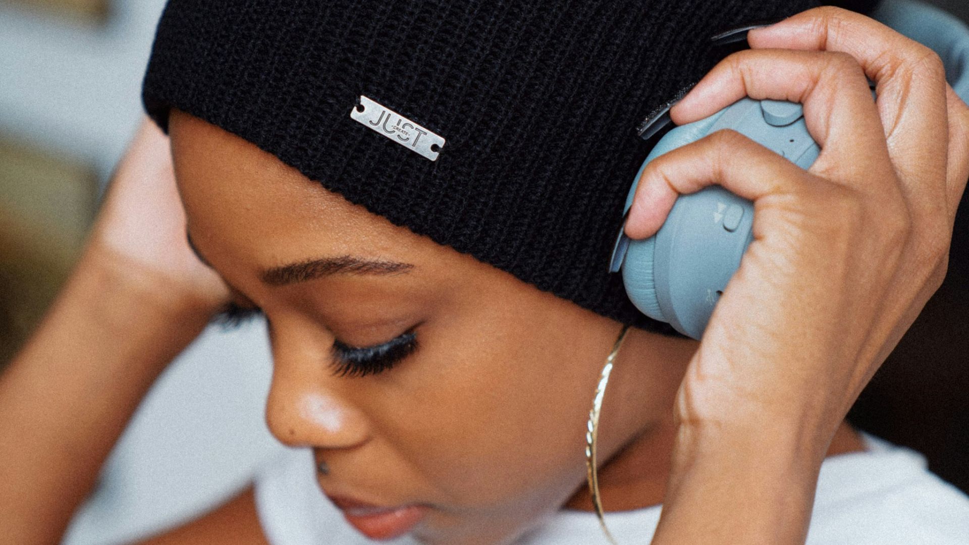 woman in white shirt wearing black knit cap