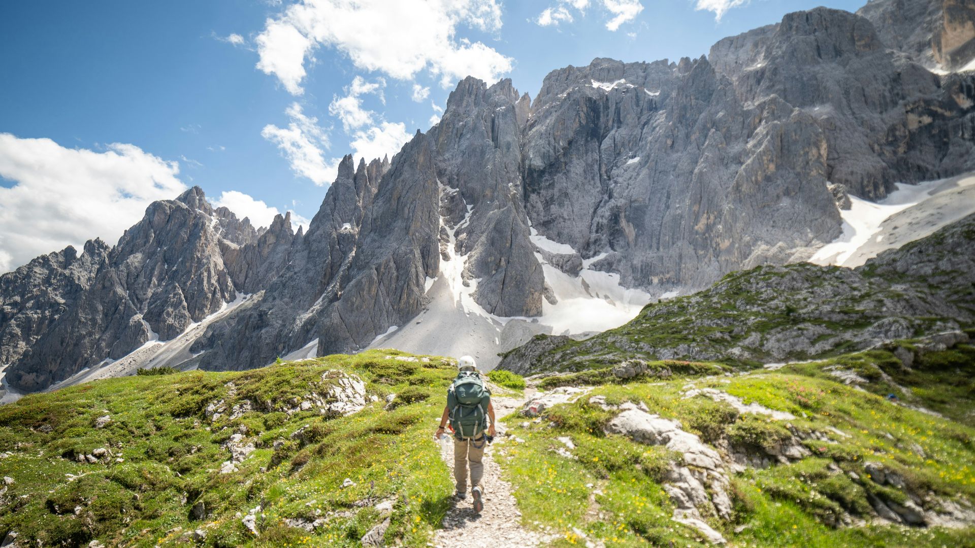 a man hiking up a trail in the mountains