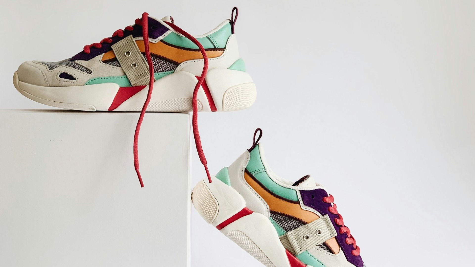 pair of white-and-orange athletic shoes on white box