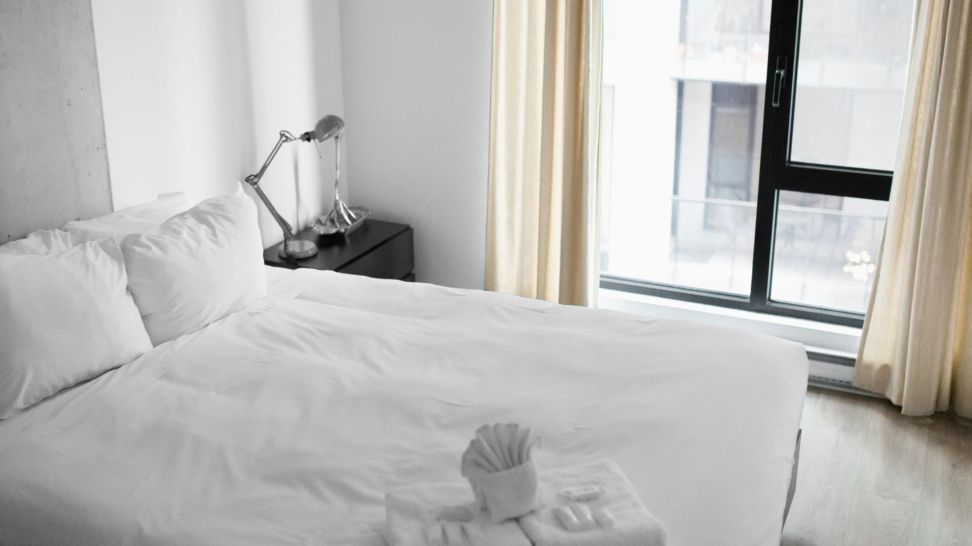 vacant white bed near the window