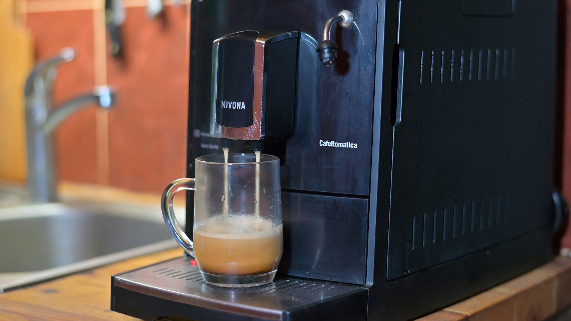 a glass of liquid sits on a coffee maker