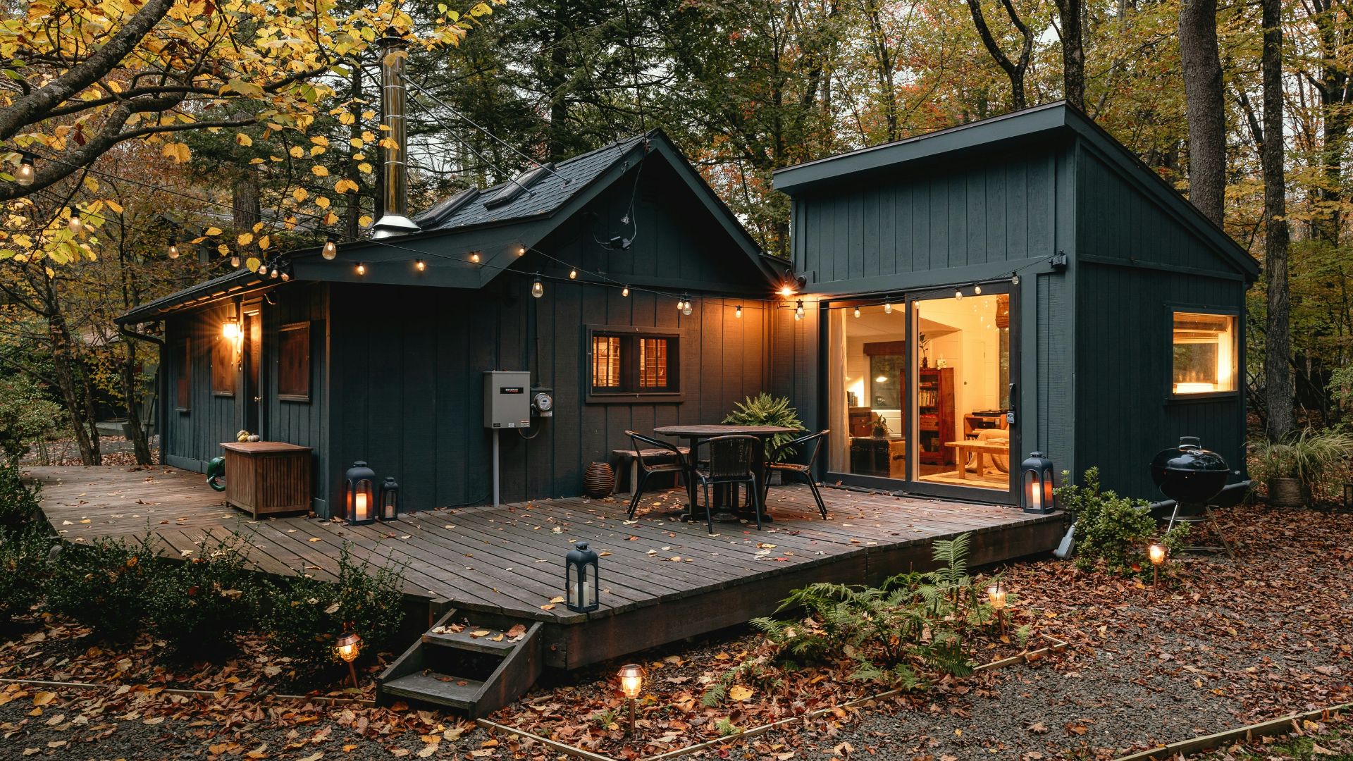 a small cabin with a deck in the woods