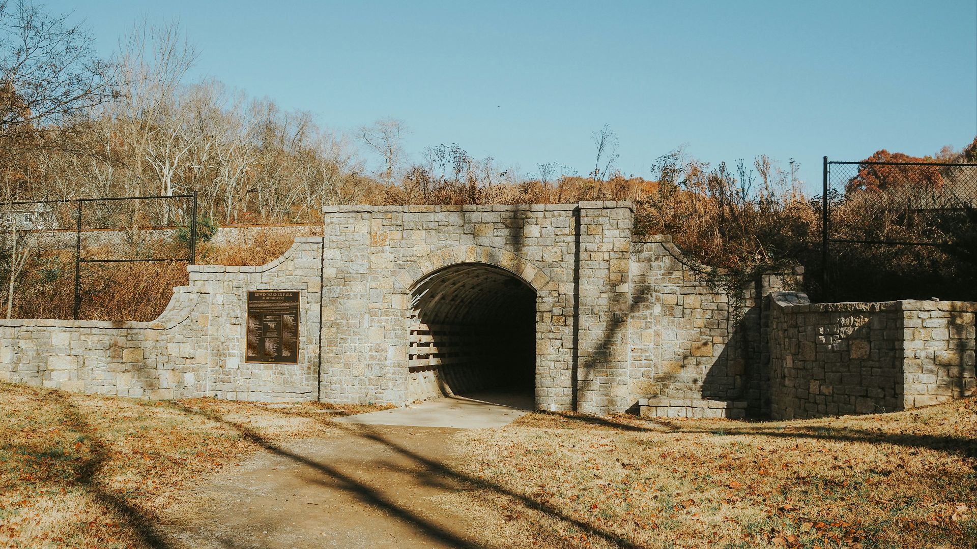 a stone tunnel with a gate in the middle of it
