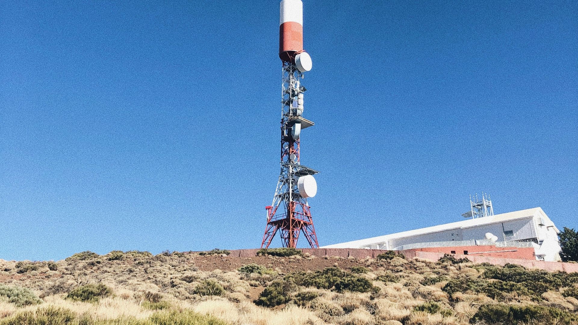 a very tall tower sitting in the middle of a field