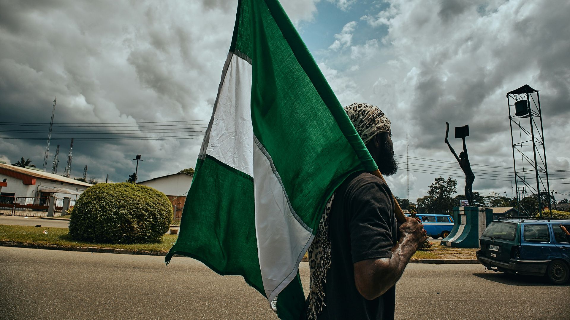 woman in black and white hijab holding green flag