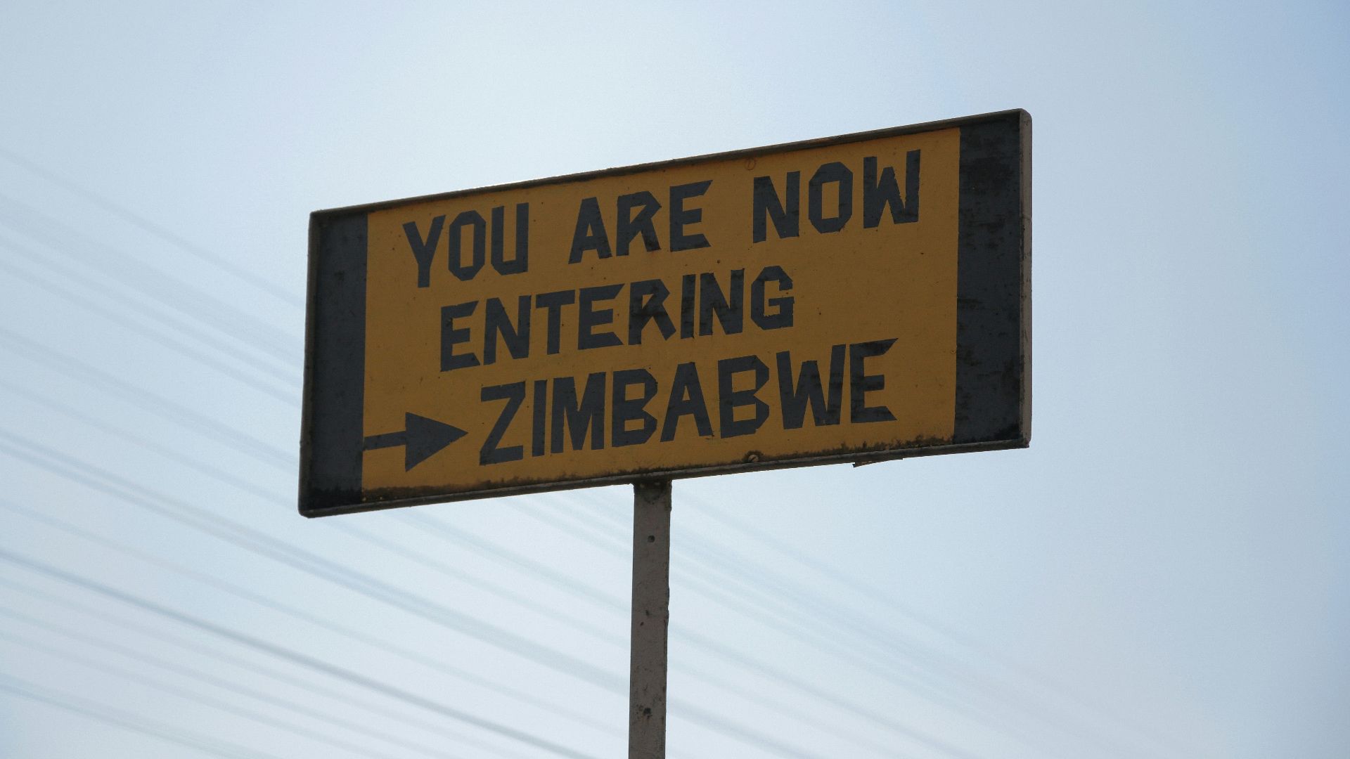 a street sign that says you are now entering zimbawe