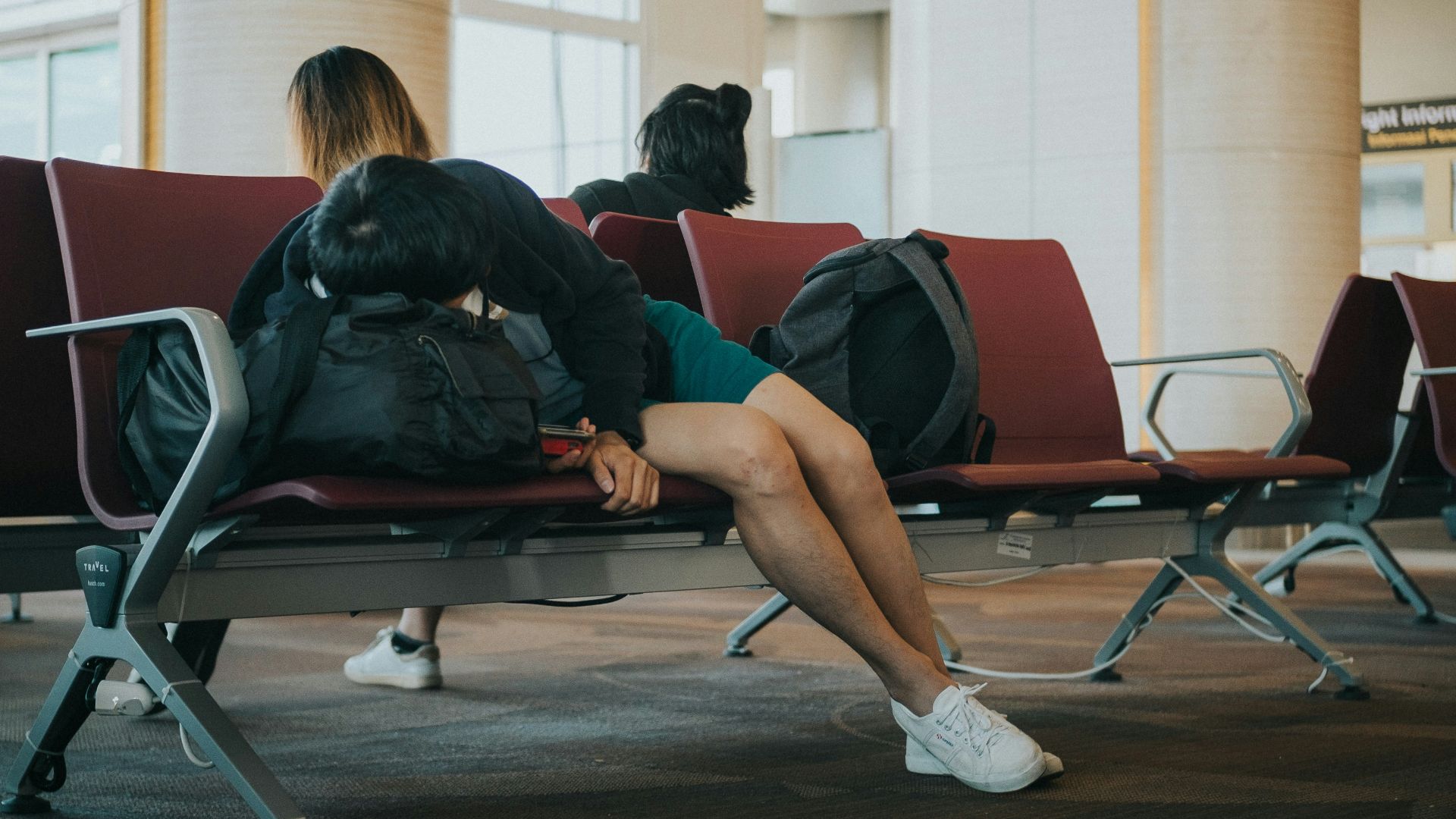 unknown person lying on brown bench indoors