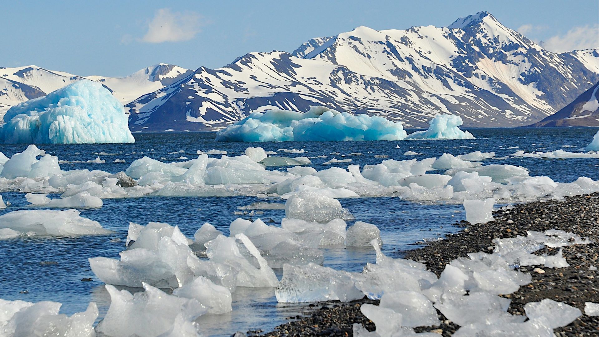 a group of icebergs floating on top of a body of water