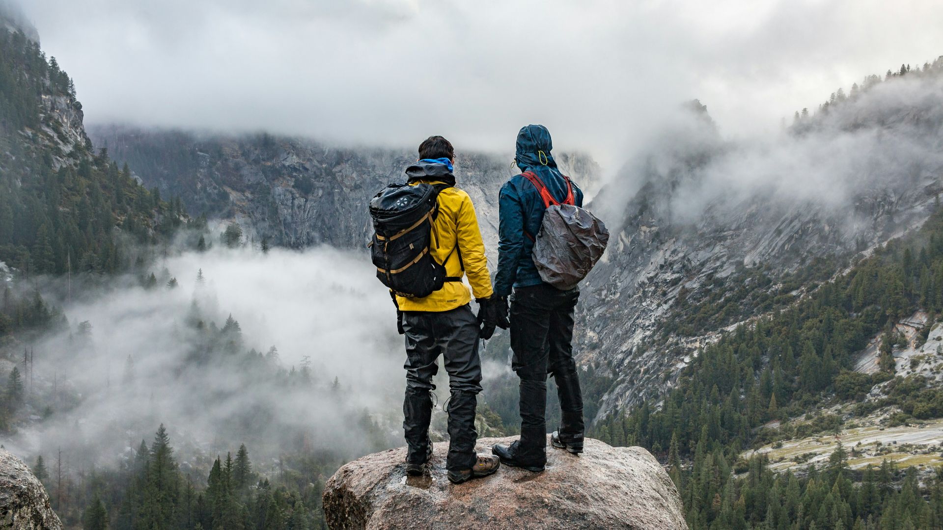 two men standing near cliff during daytime