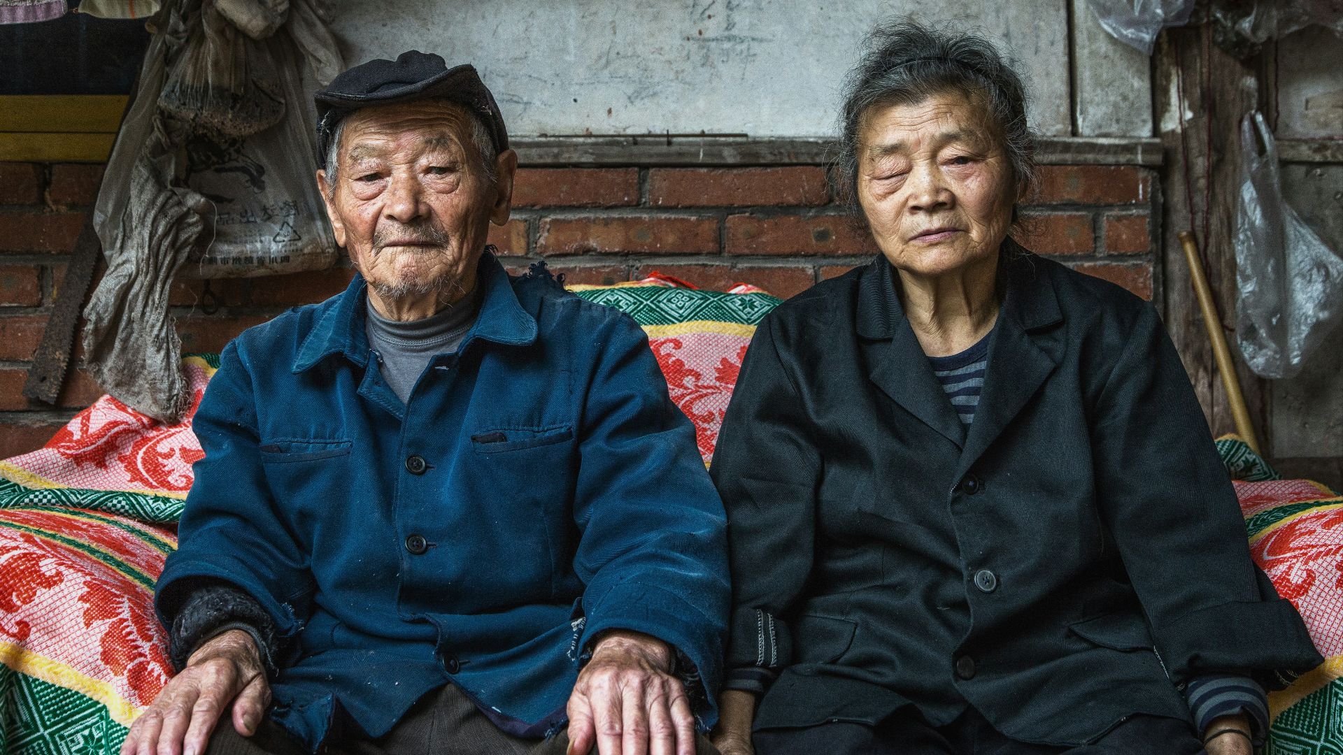 senior couple sitting on sofa beside wall