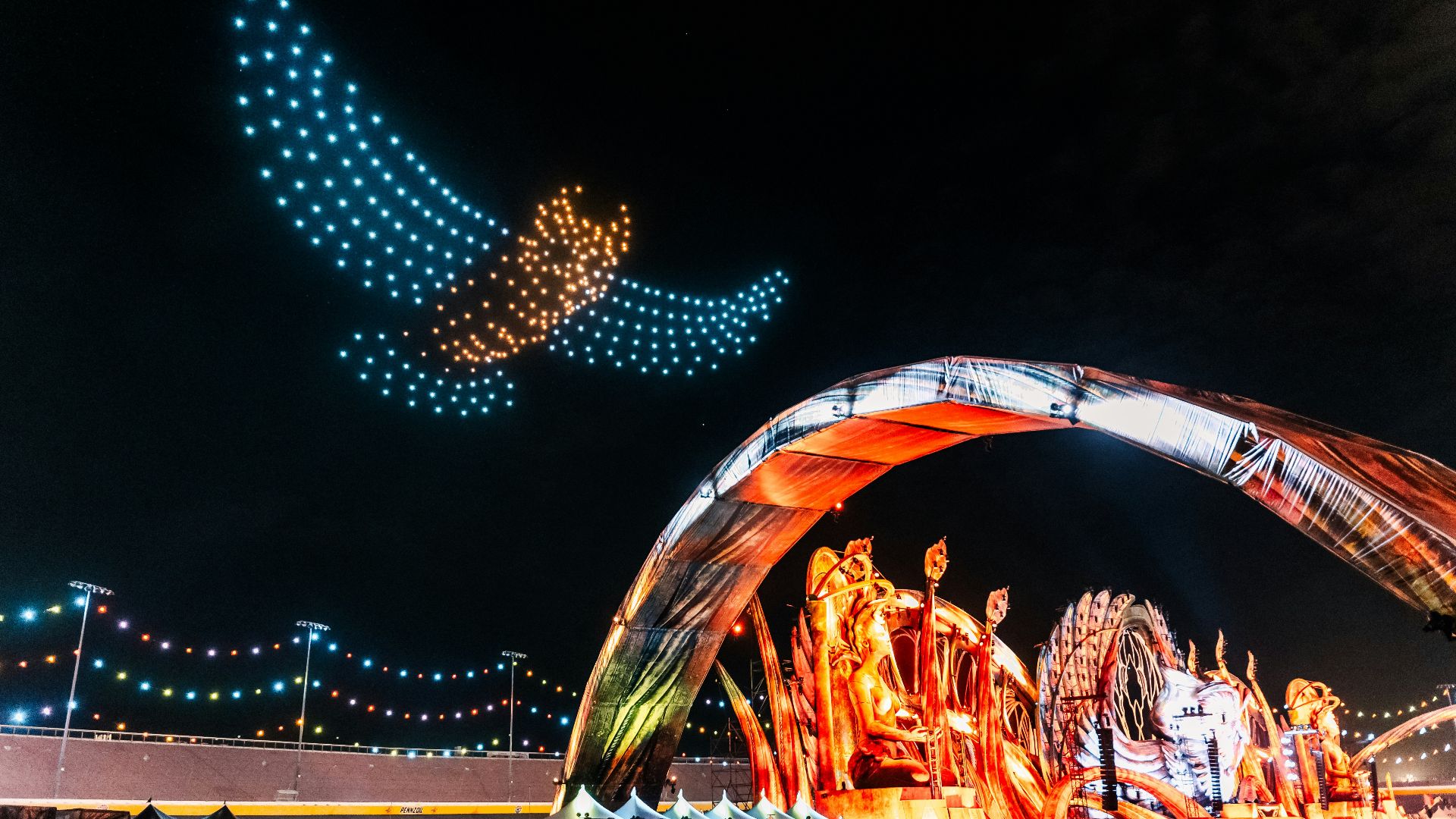 a crowd of people standing around a carnival at night