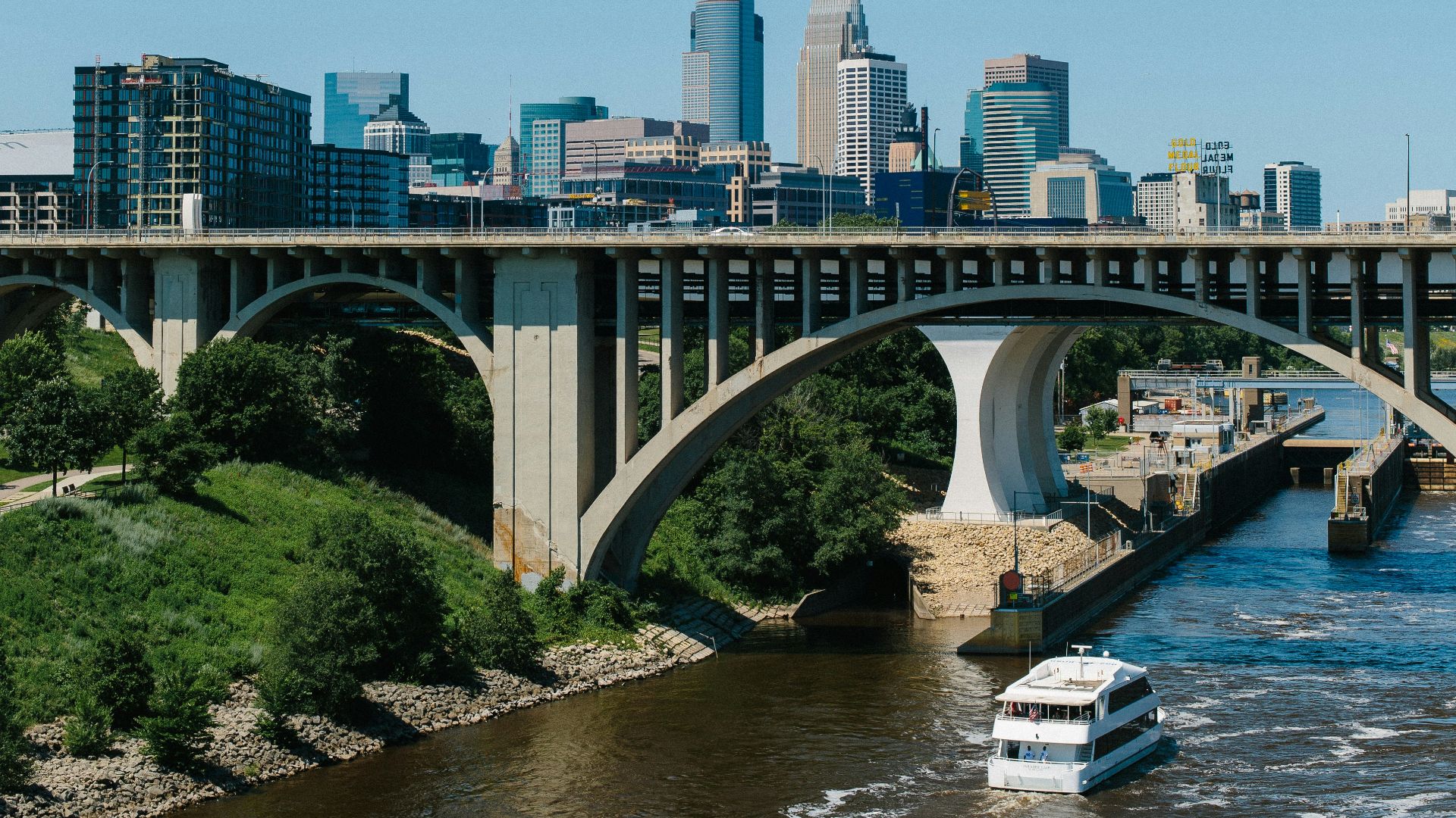a boat traveling down a river under a bridge