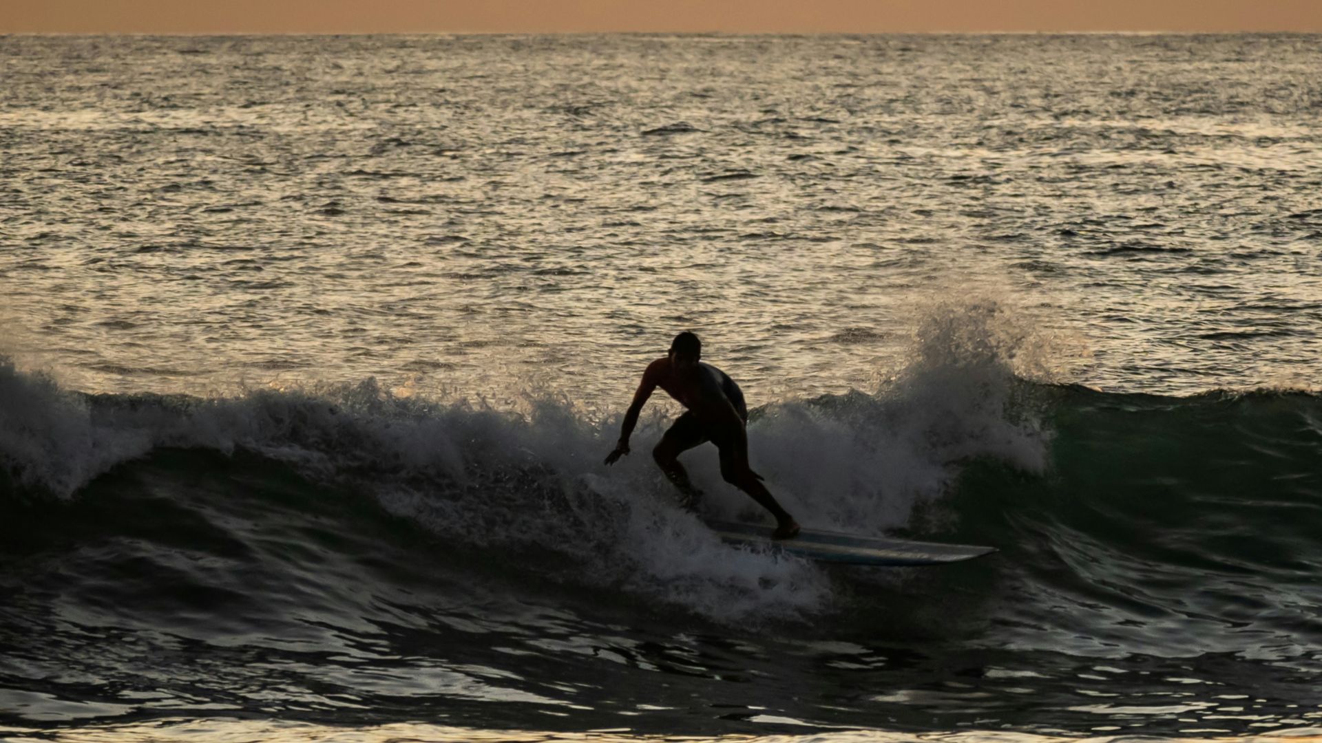 a man riding a wave on top of a surfboard