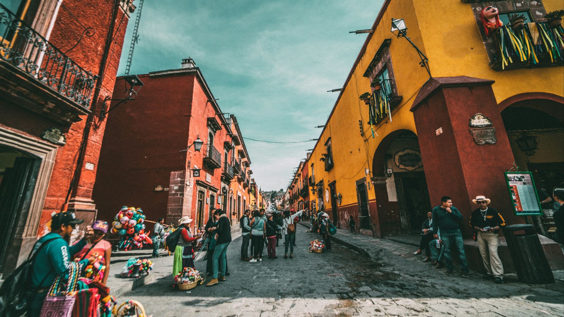 people standing on corner road near concrete buildings during daytime