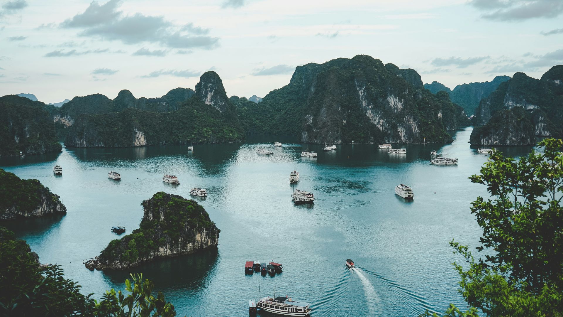 high-angle photography of boats on water near hill during daytime