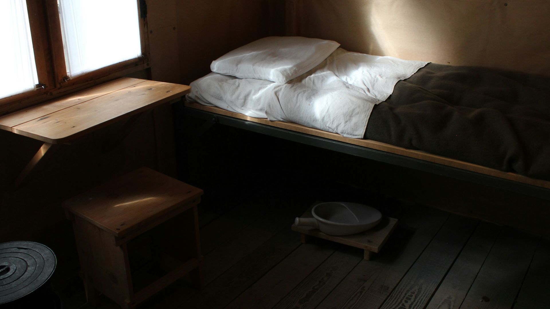 a bed sitting in a bedroom next to a window