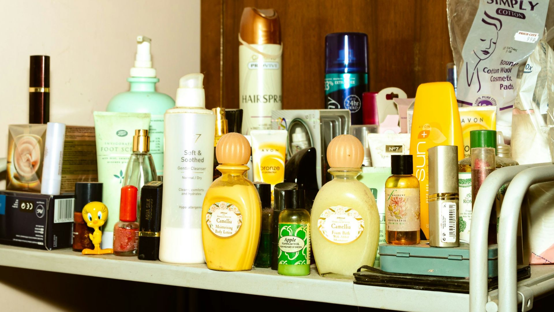 white and yellow plastic bottle on brown wooden shelf