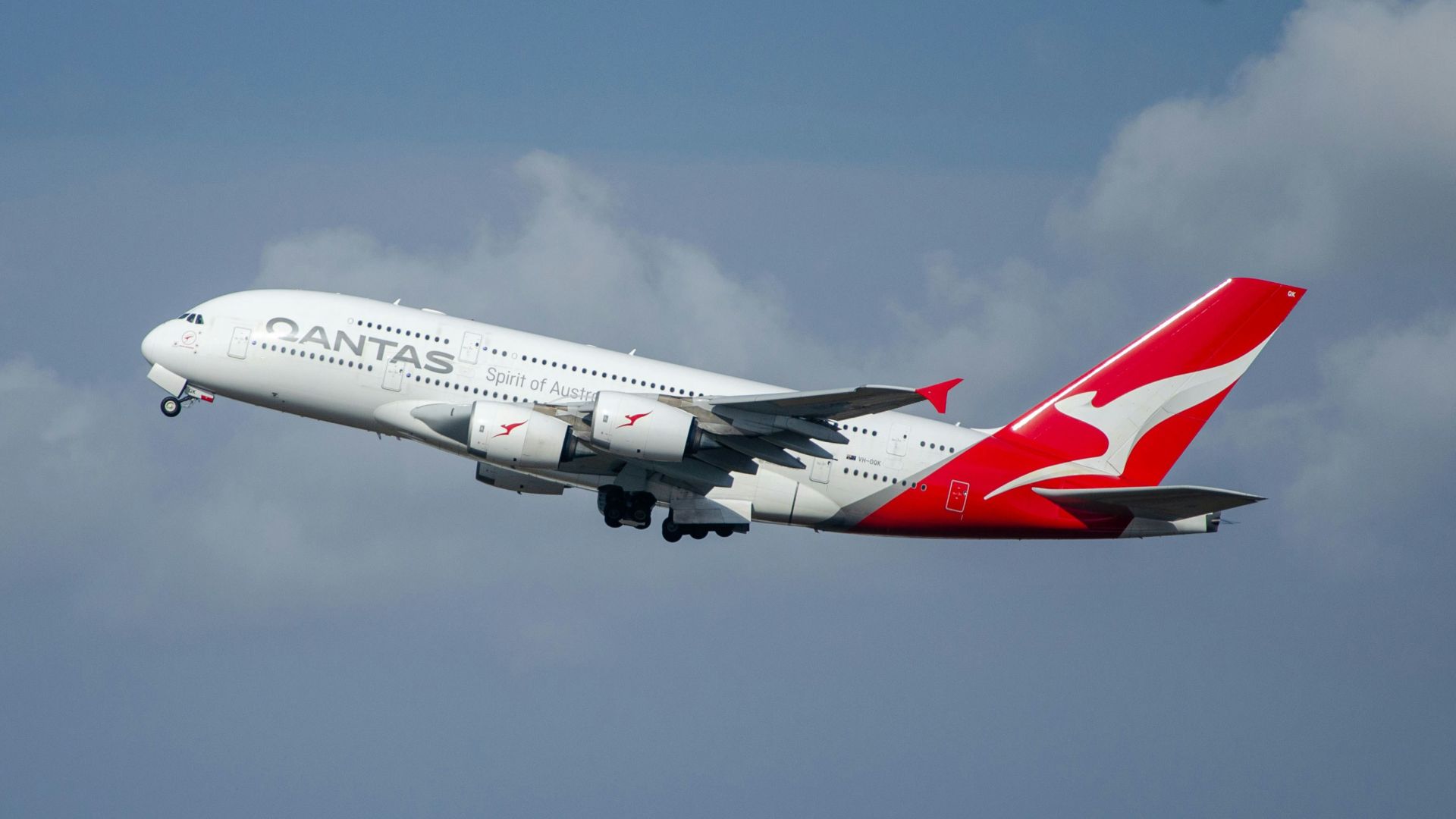 a large passenger jet flying through a cloudy blue sky