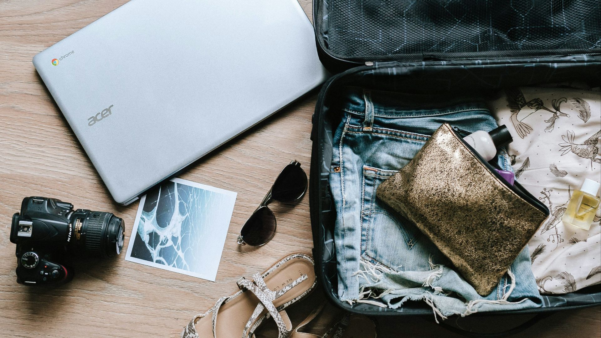 black DSLR camera near sunglasses and bag