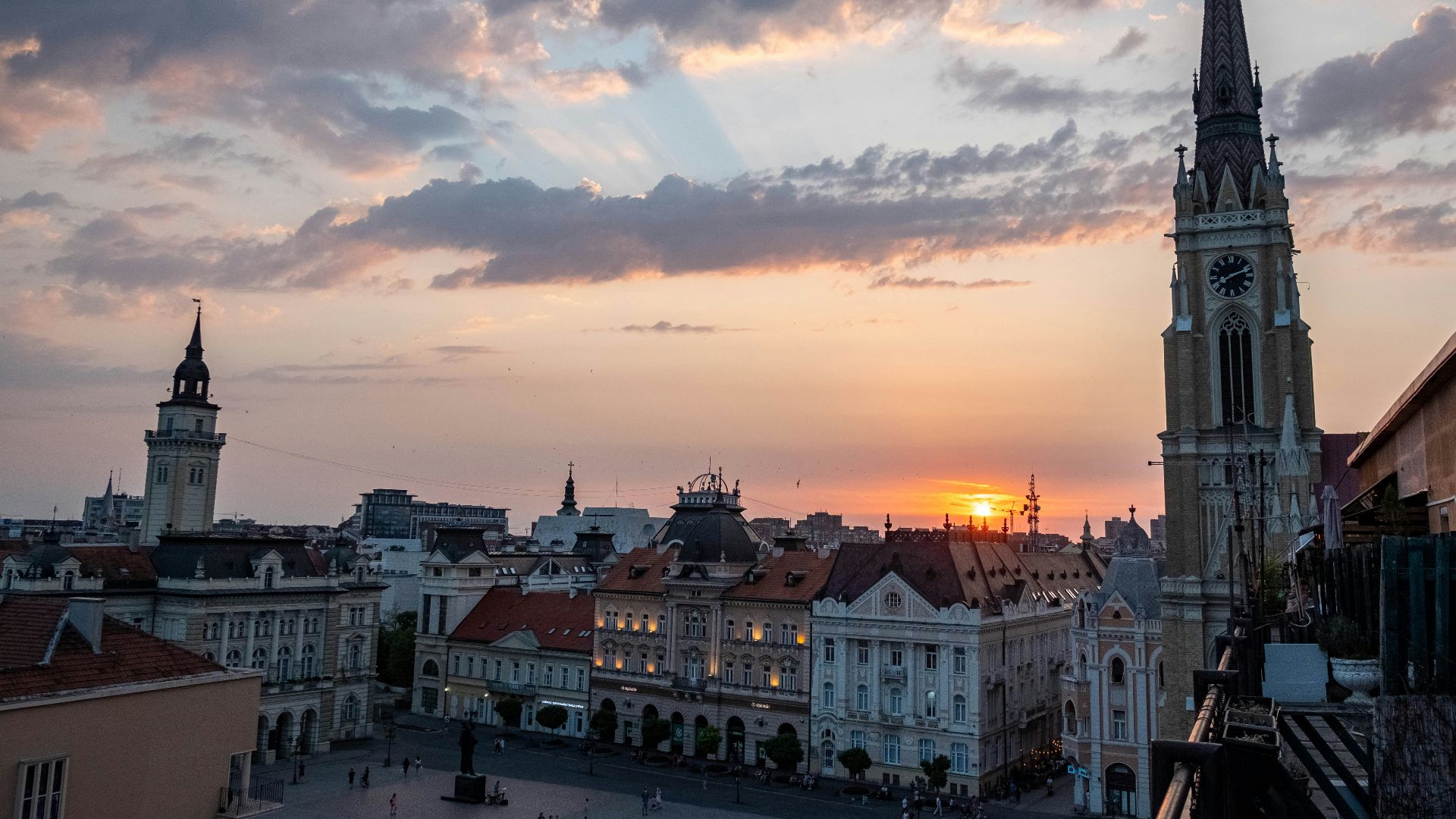 the sun is setting over a city with tall buildings