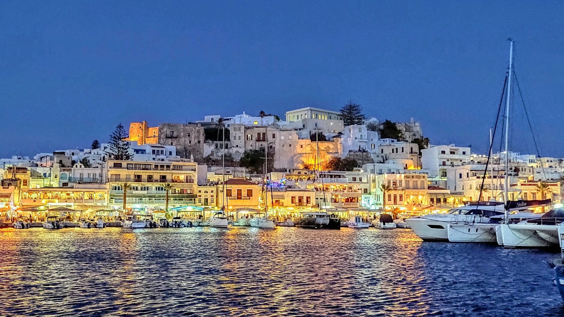 city buildings near body of water during night time