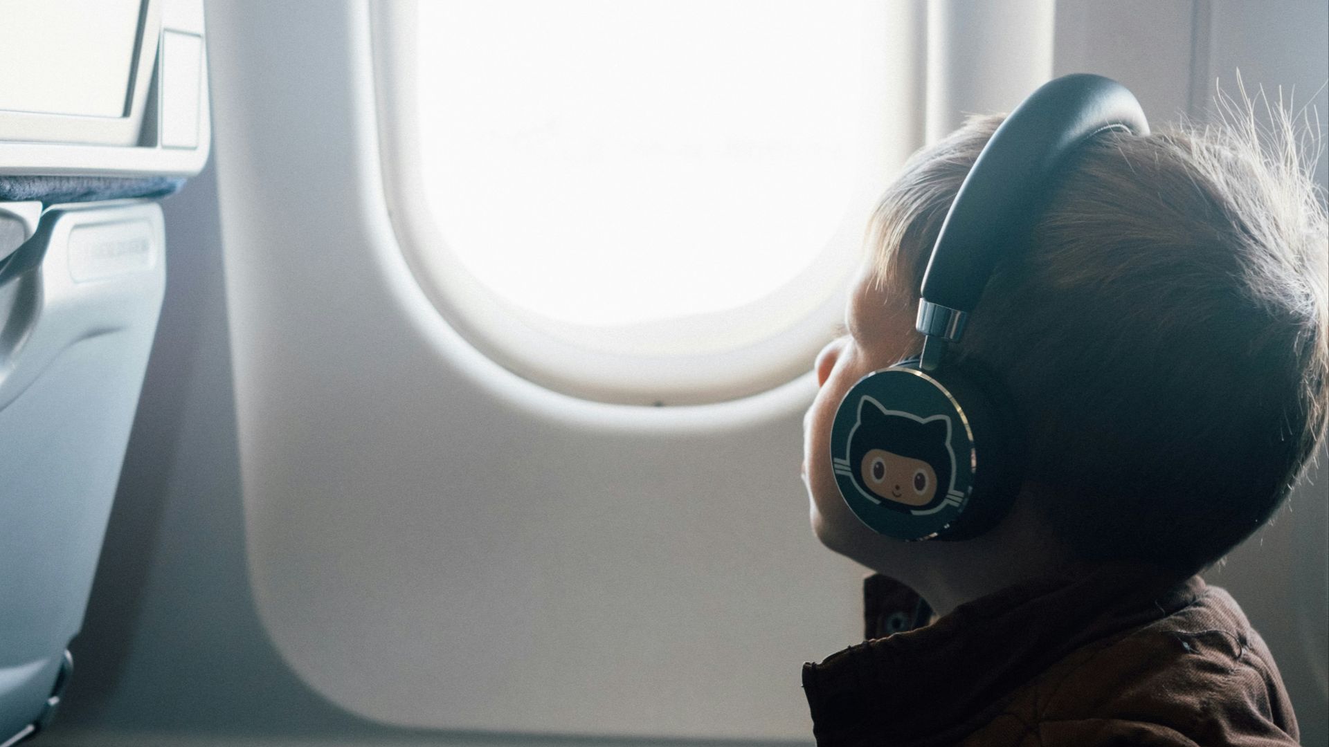 girl in red and brown sweater wearing white and blue headphones