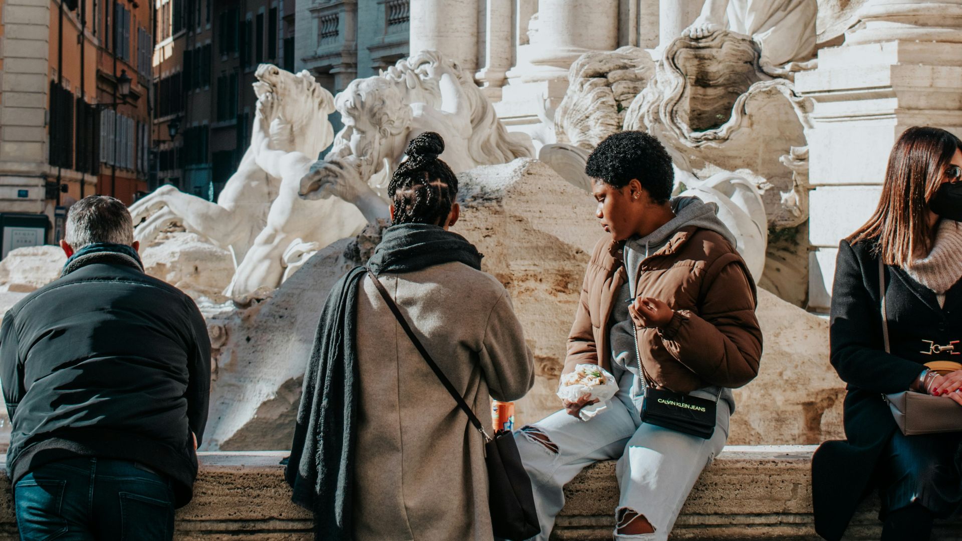 a group of people standing around a fountain