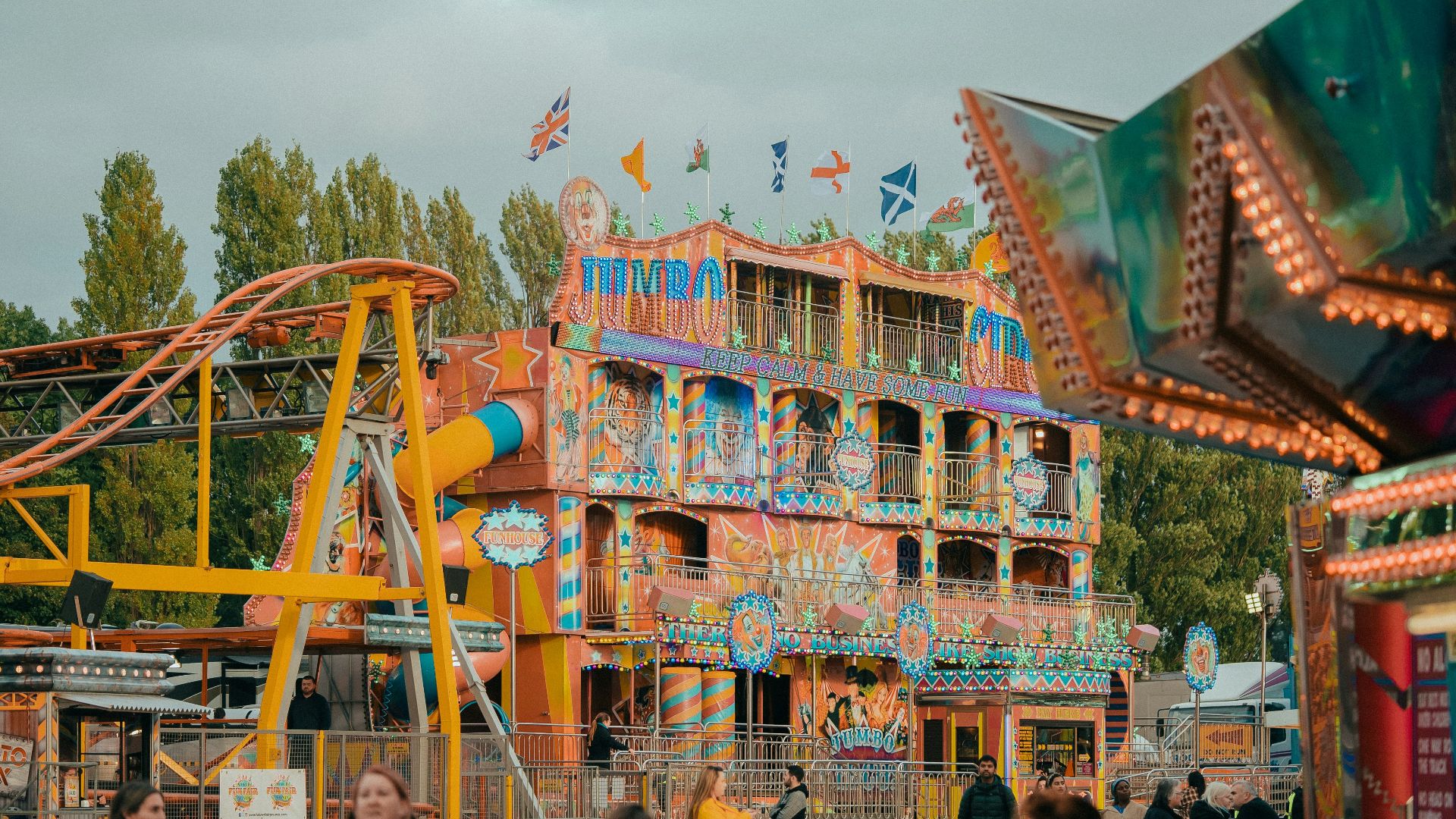 a carnival ride with a colorful building in the background