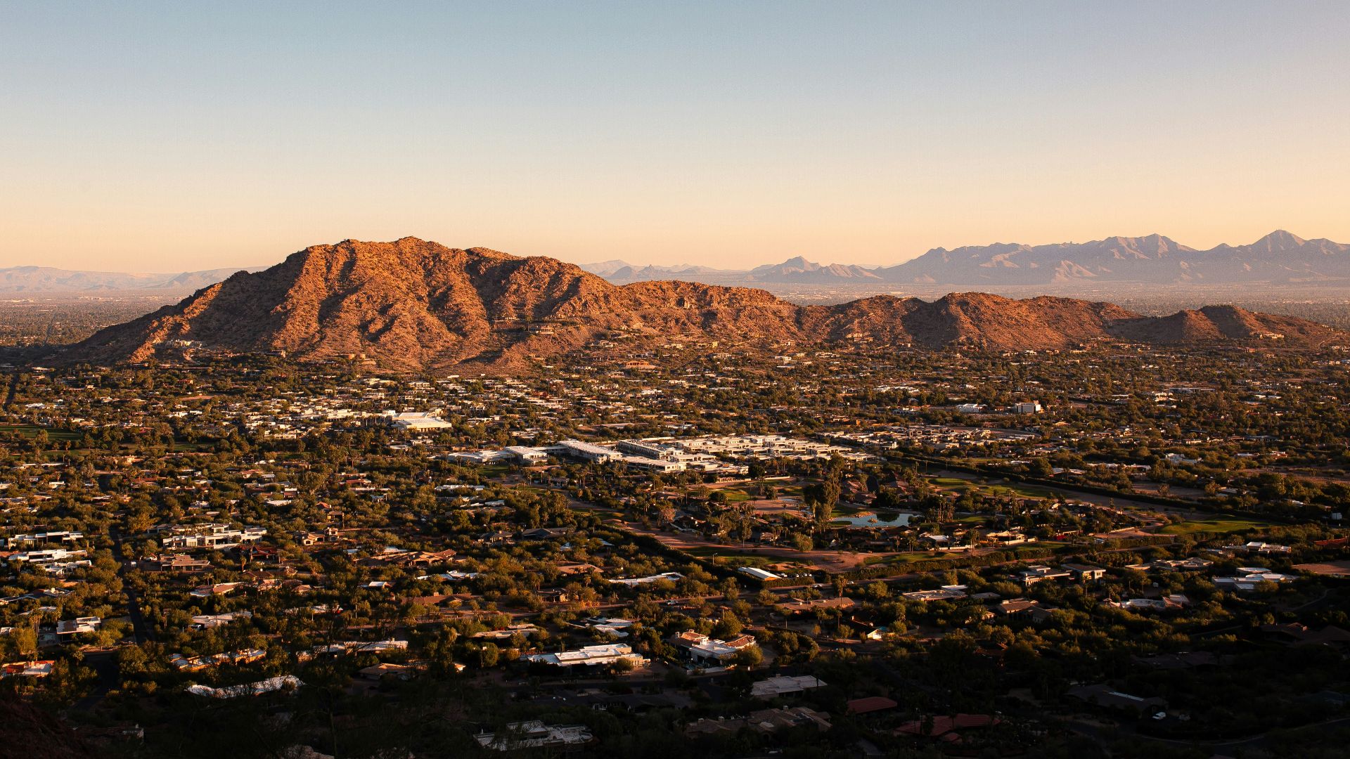 an aerial view of a city with mountains in the background