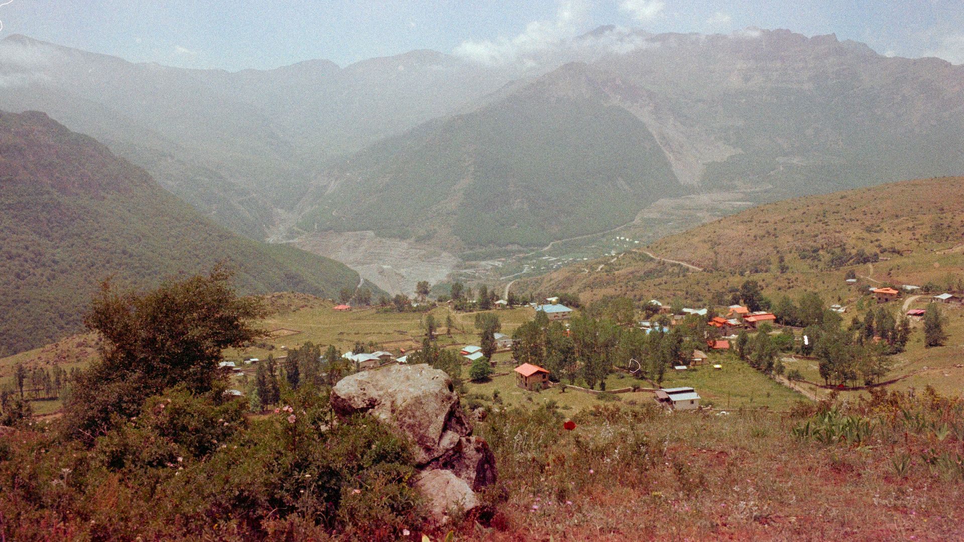 A view of a valley with mountains in the background