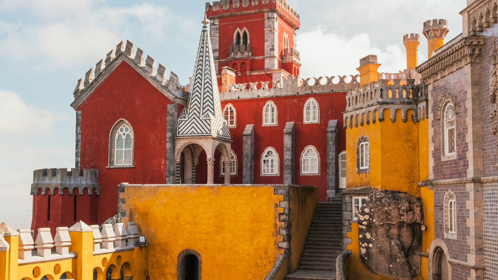 yellow and red concrete building under clear blue sky