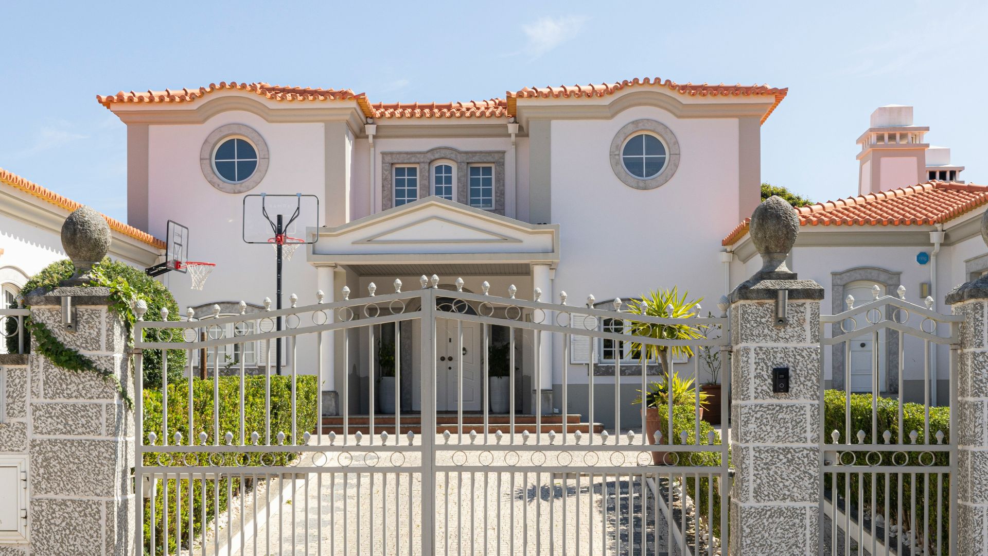A luxurious mansion with a large front gate.