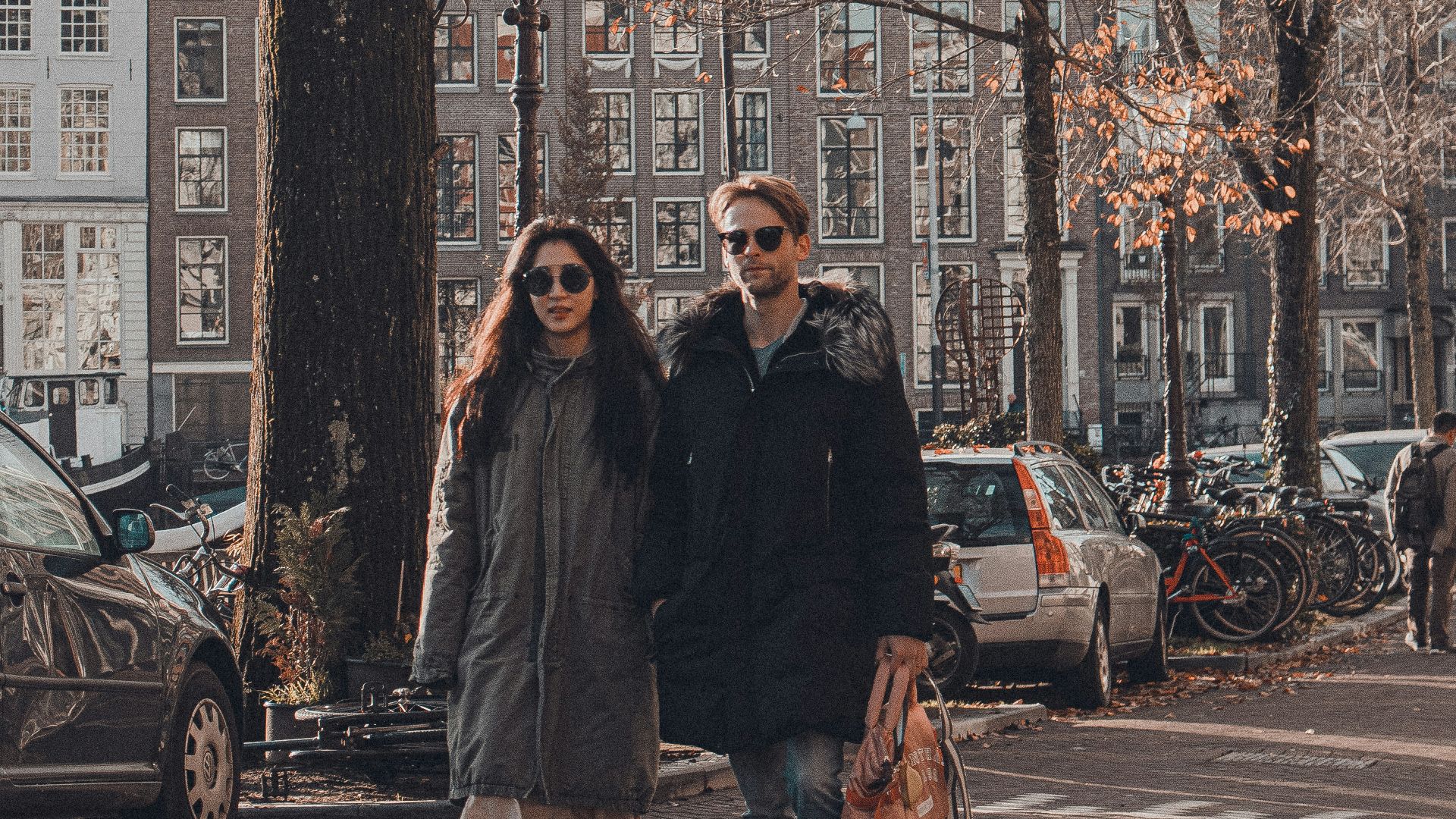 man and woman standing beside bare tree during daytime